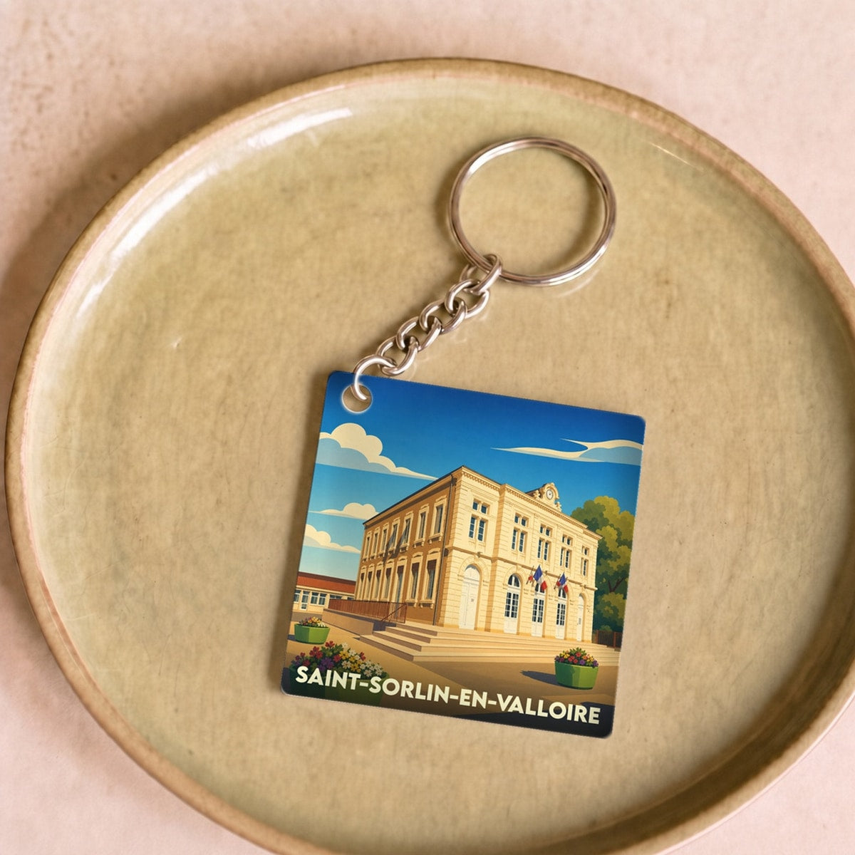 Porte-clés souvenir de la ville de Saint-Sorlin-en-Valloire avec une illustration stylisée.