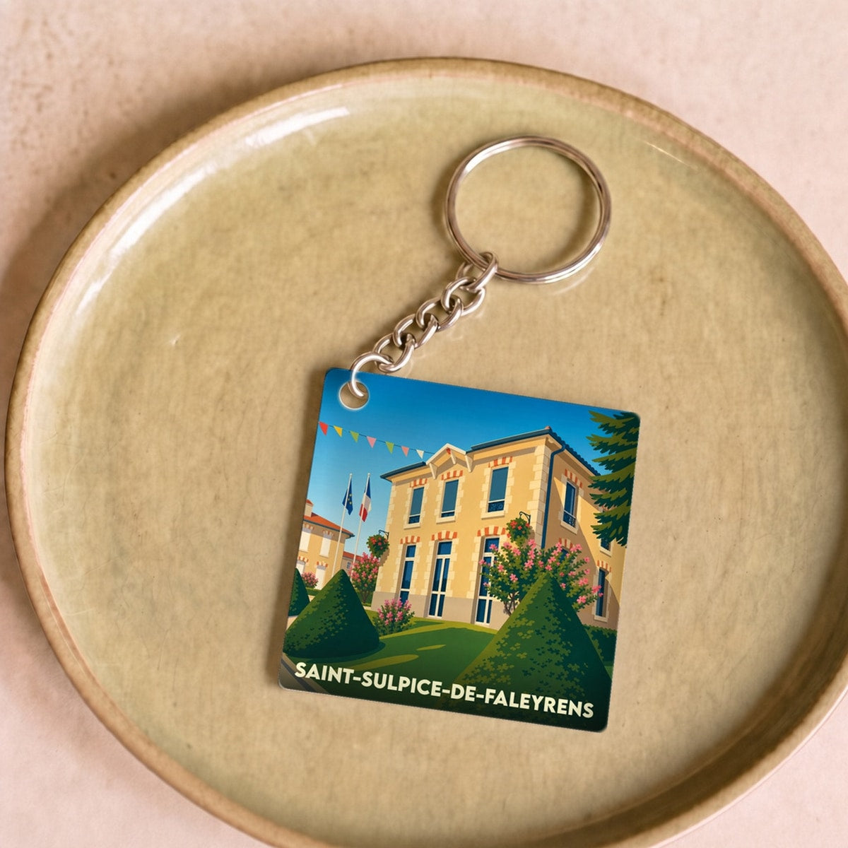Porte-clés souvenir de la ville de Saint-Sulpice-de-Faleyrens avec une illustration stylisée.