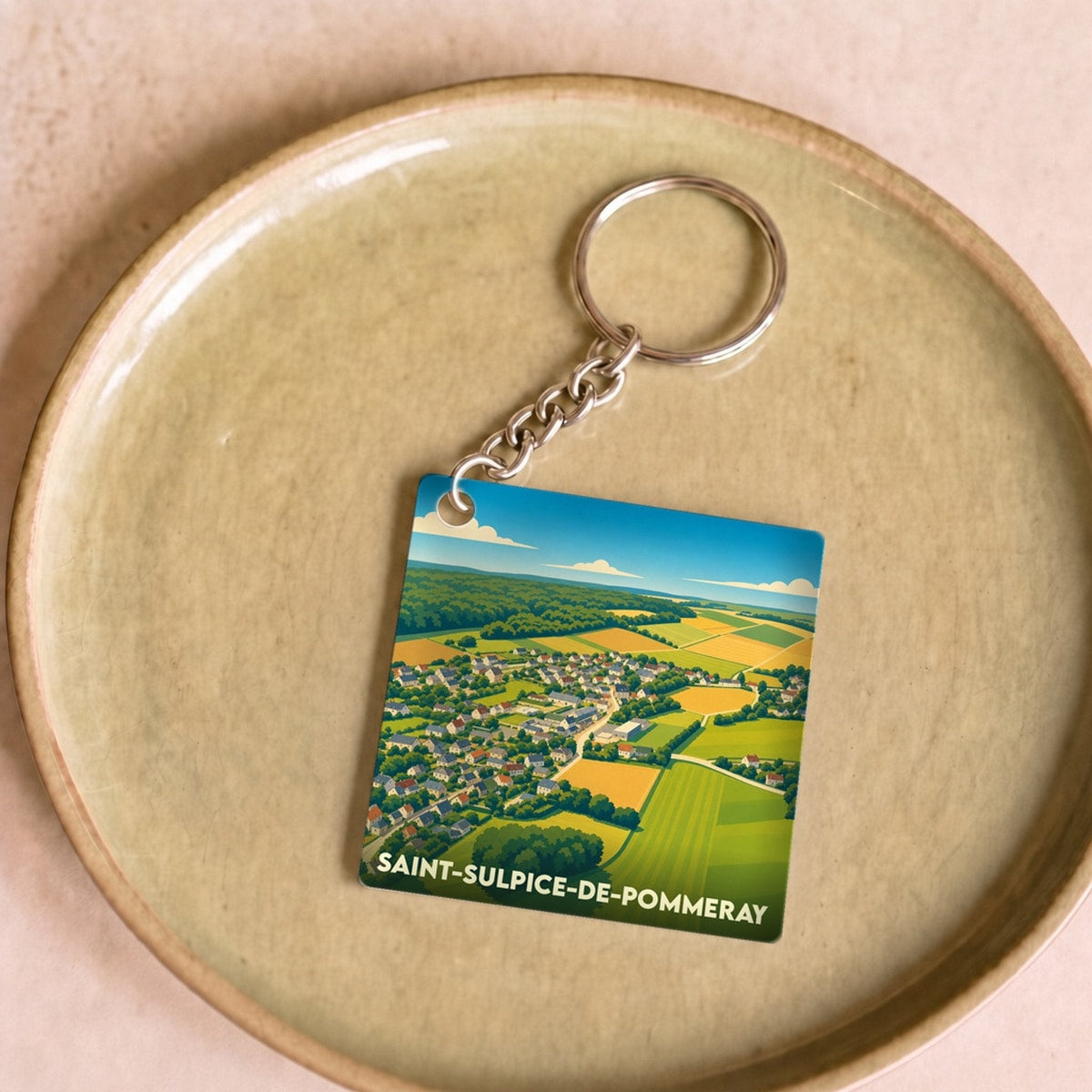 Porte-clés souvenir de Saint-Sulpice-de-Pommeray arborant une illustration paysagère stylisée du village.