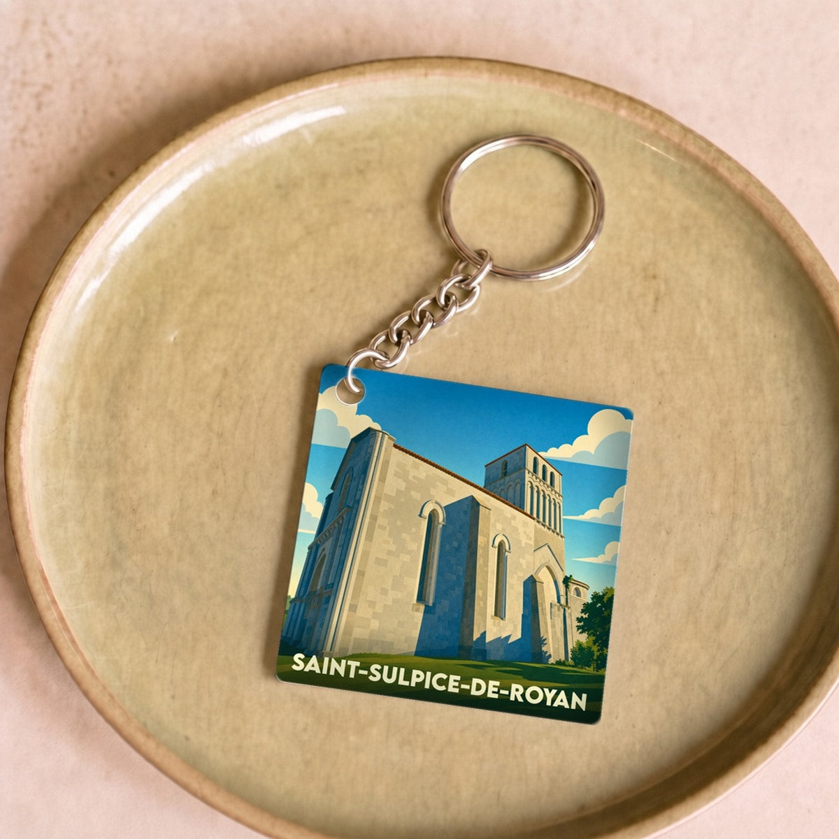 Porte-clés souvenir de Saint-Sulpice-de-Royan avec une illustration stylisée de son église romane.