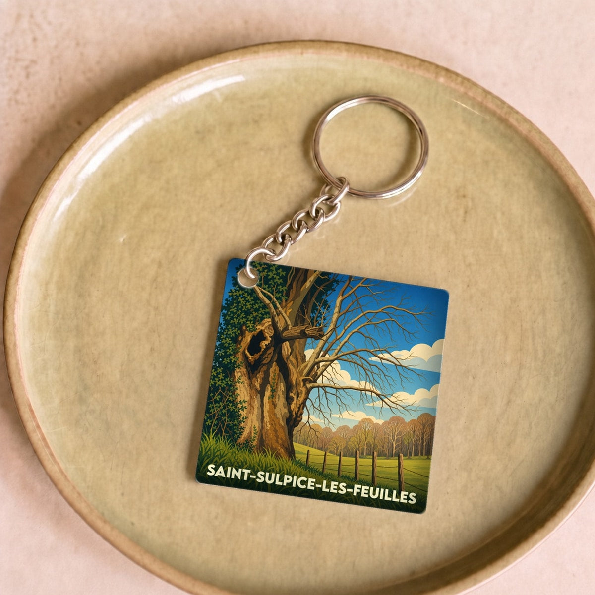 Porte-clés souvenir de la ville de Saint-Sulpice-les-Feuilles avec une illustration stylisée d'un vieil arbre.