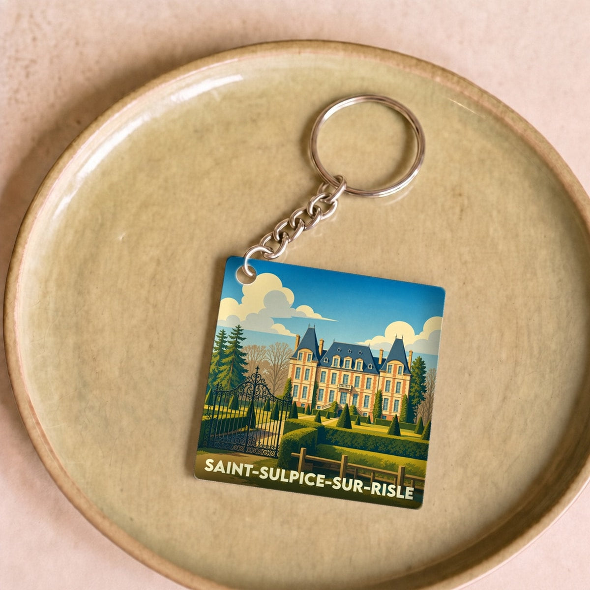 Porte-clés souvenir de la ville de Saint-Sulpice-sur-Risle avec une illustration stylisée d'un château.