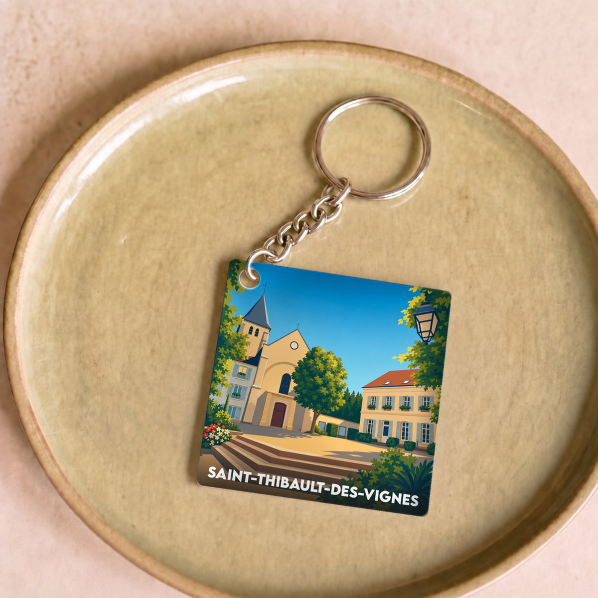 Porte-clés souvenir de la ville de Saint-Thibault-des-Vignes avec une illustration stylisée.