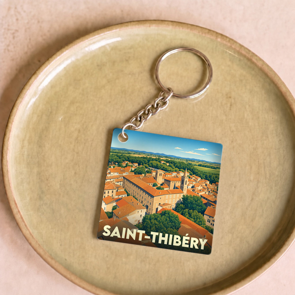 Porte-clés souvenir de la ville de Saint-Thibéry avec une illustration stylisée.