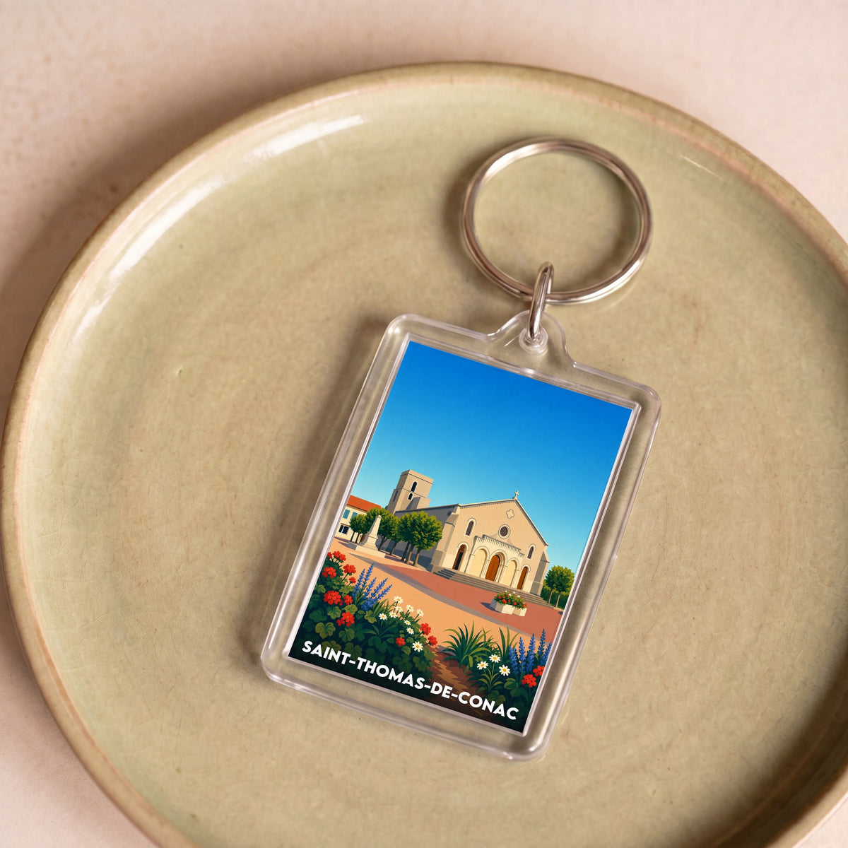 Porte-clés souvenir de la ville de Saint-Thomas-de-Conac avec une illustration stylisée.
