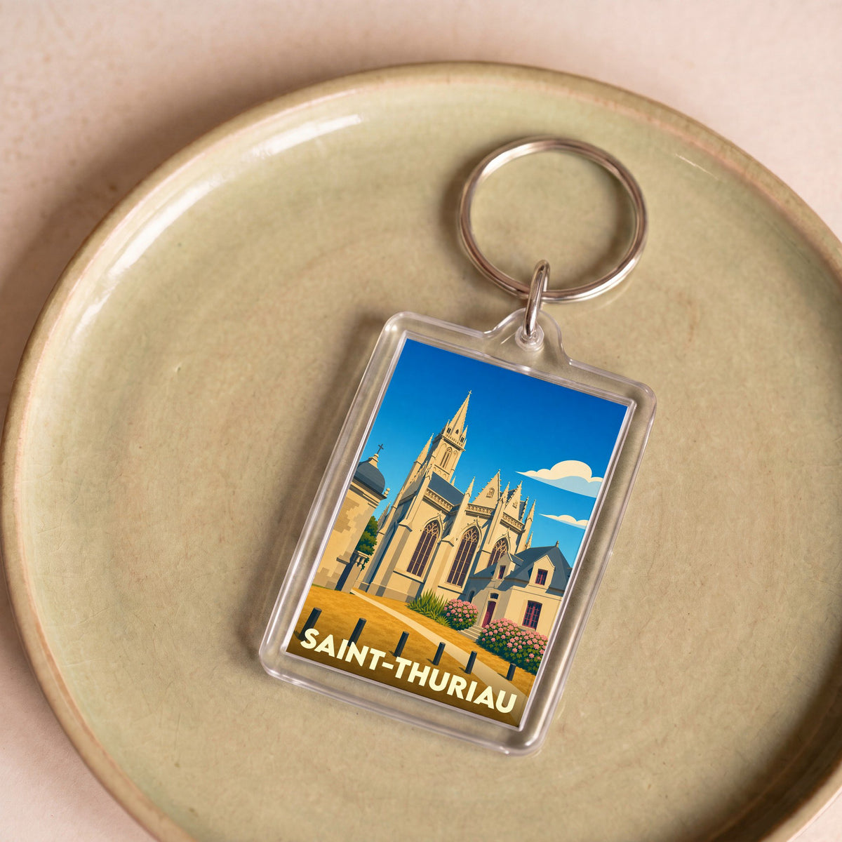 Porte-clés souvenir de la ville de Saint-Thuriau avec une illustration stylisée de son église.