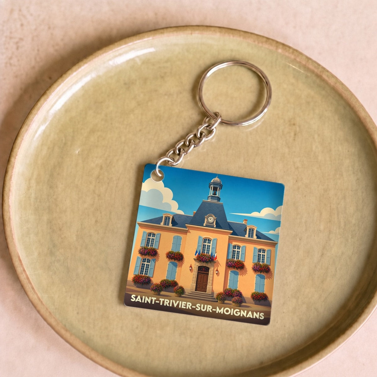 Porte-clés souvenir de la ville de Saint-Trivier-sur-Moignans avec une illustration stylisée de sa mairie.