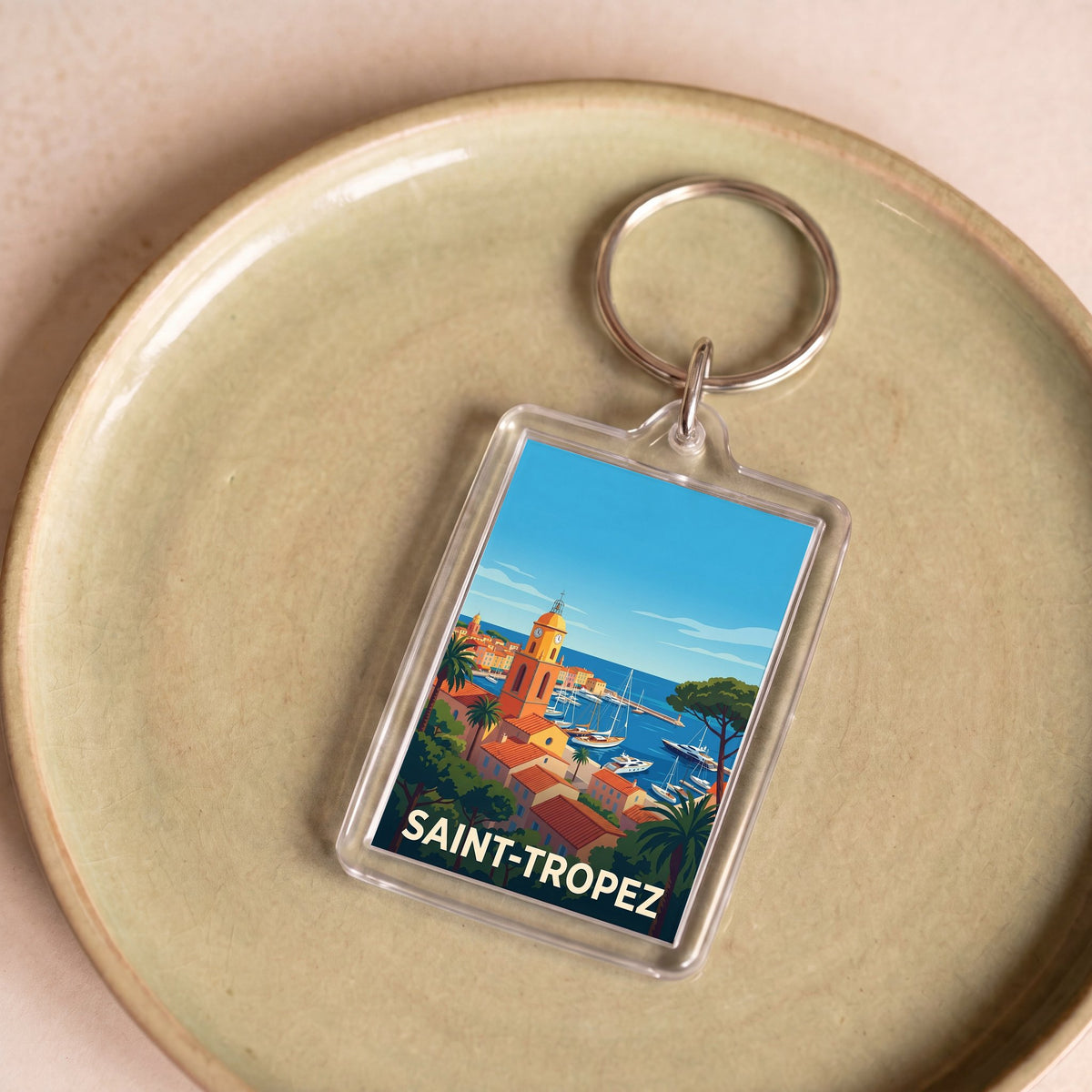 Porte-clés souvenir de la ville de Saint-Tropez avec une illustration stylisée.
