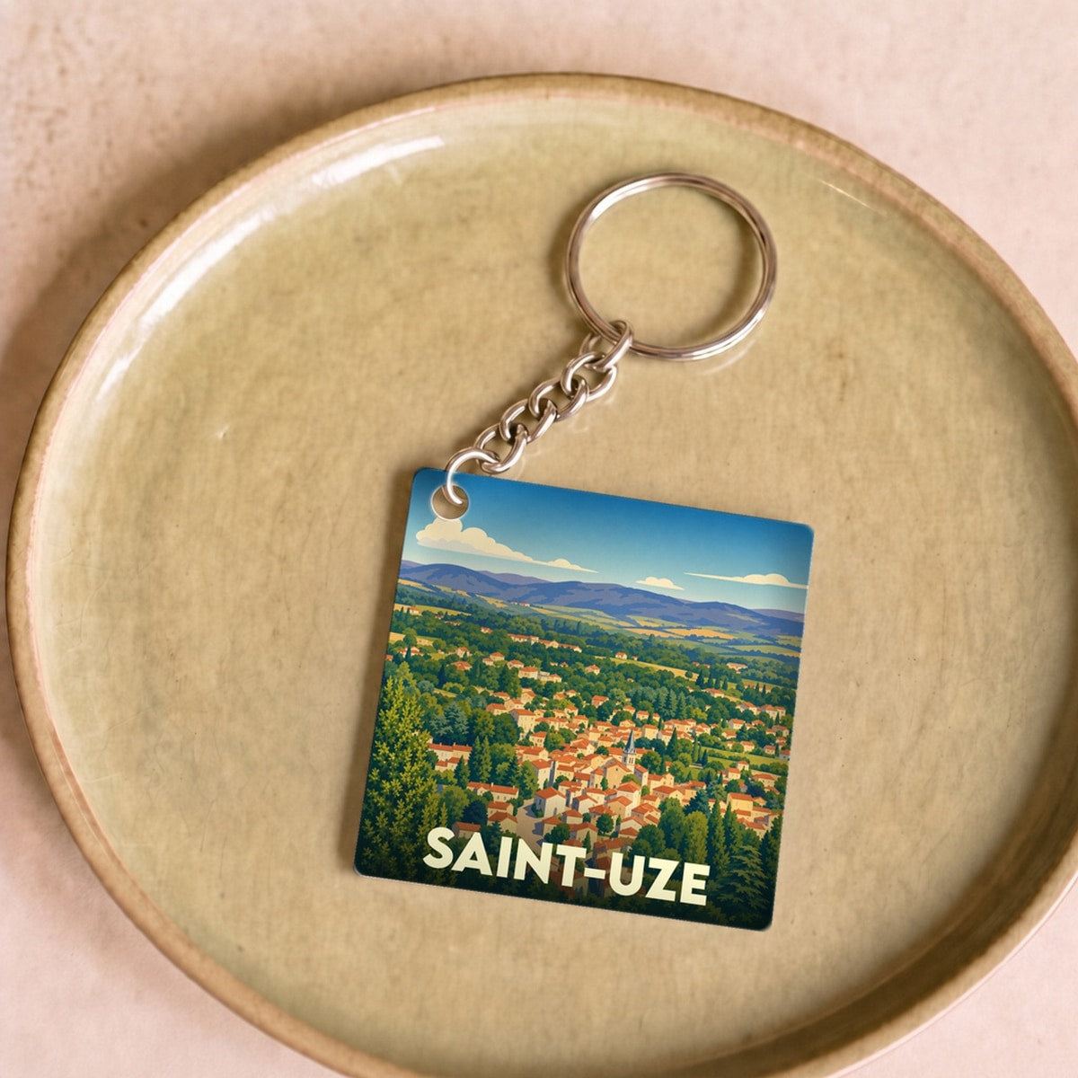 Porte-clés souvenir de la ville de Saint-Uze avec une illustration stylisée.