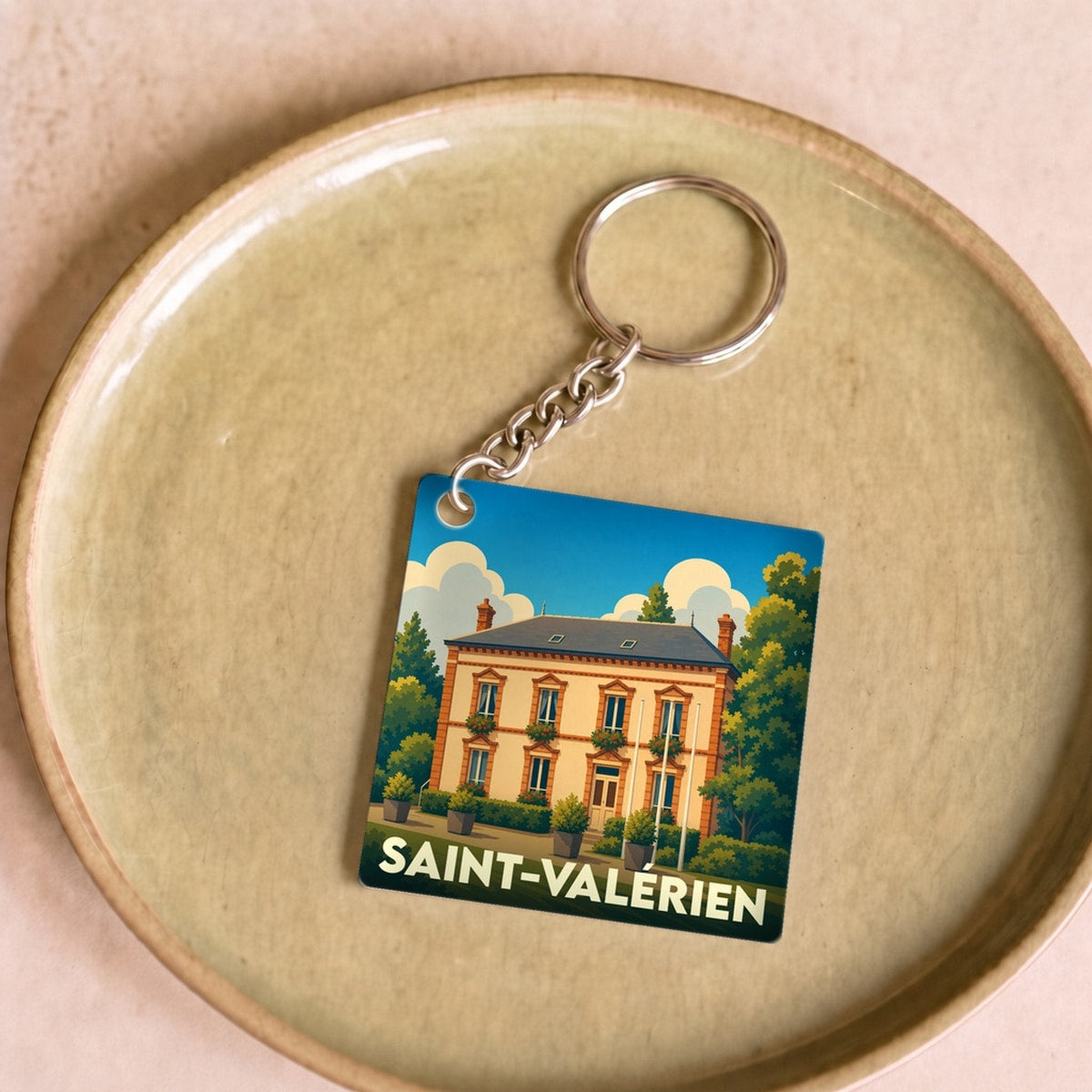 Porte-clés souvenir de la ville de Saint-Valérien avec une illustration stylisée d'une demeure bourgeoise.