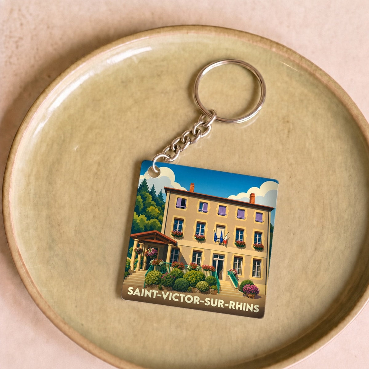Porte-clés souvenir de la ville de Saint-Victor-sur-Rhins avec une illustration stylisée.