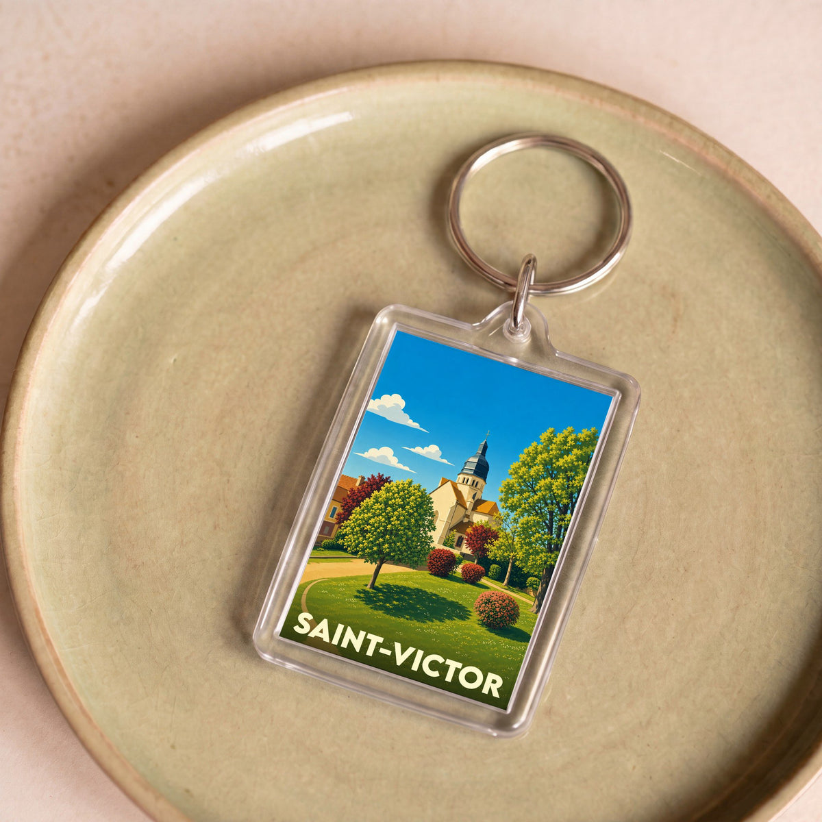 Porte-clés souvenir de la ville de Saint-Victor avec une illustration stylisée.
