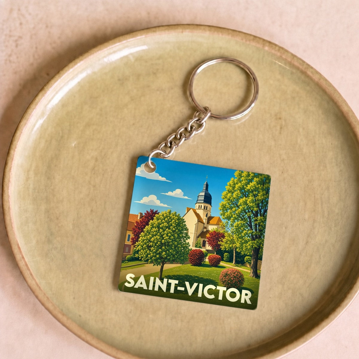 Porte-clés souvenir de la ville de Saint-Victor avec une illustration stylisée.