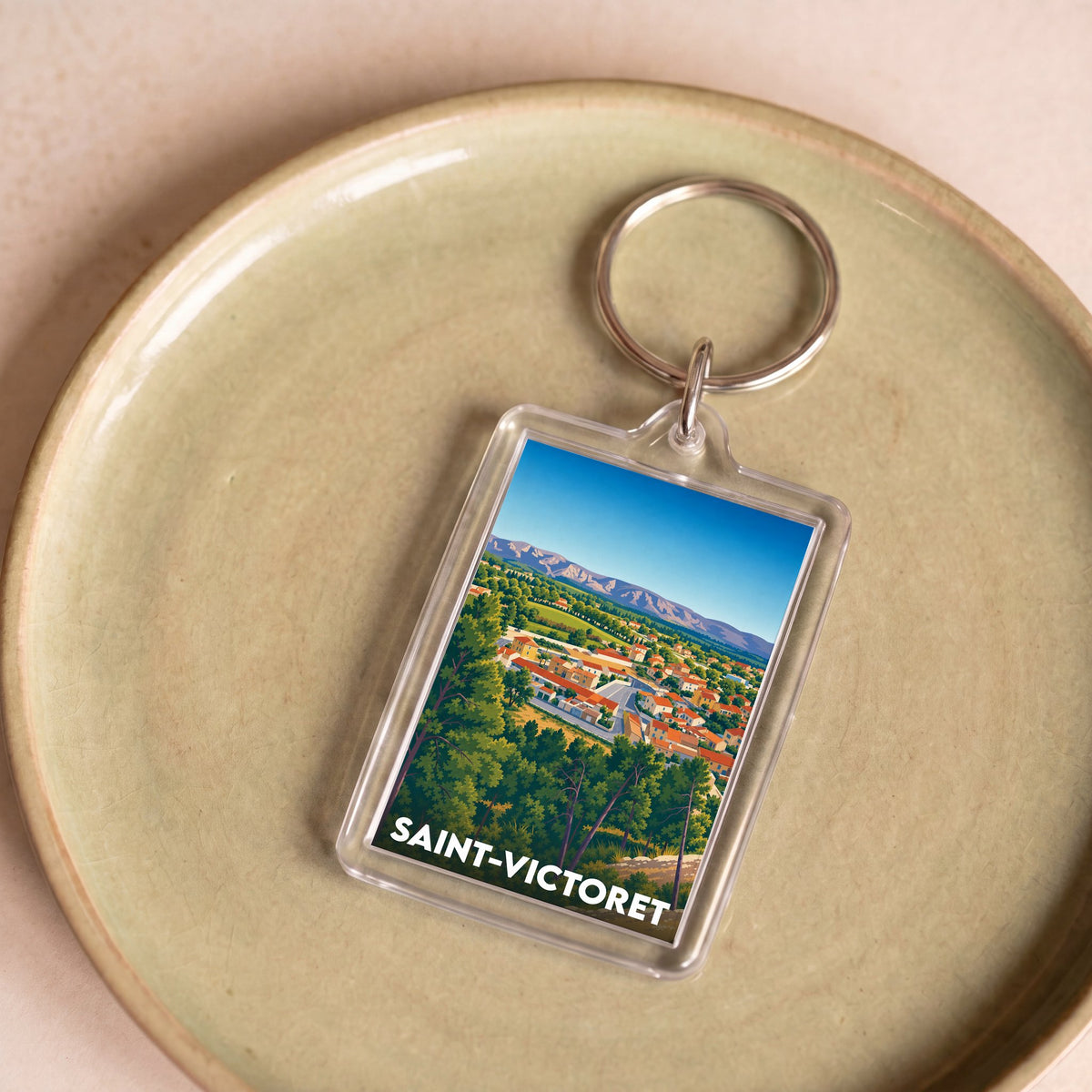 Porte-clés souvenir de la ville de Saint-Victoret avec une illustration de paysage urbain.