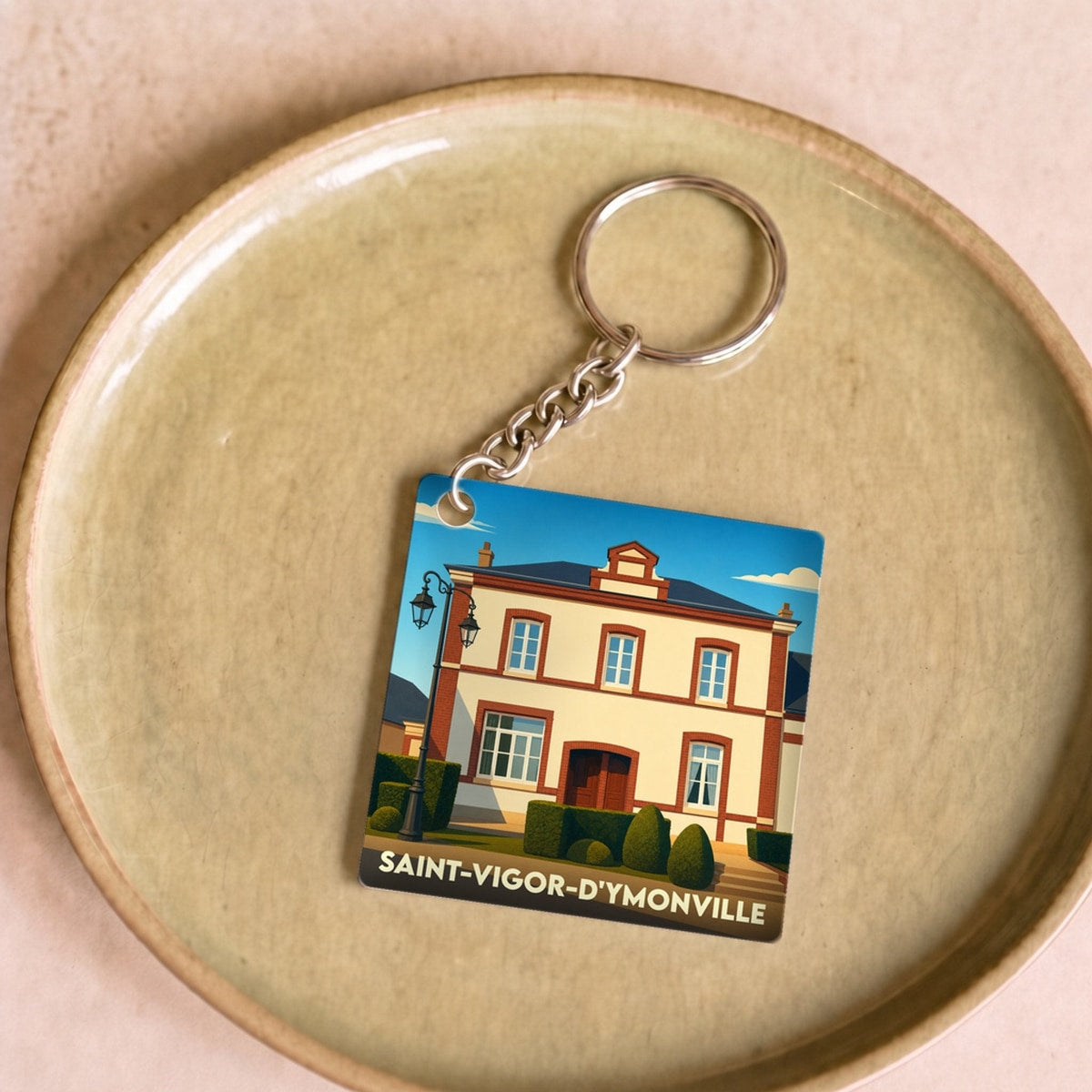 Porte-clés souvenir de la ville de Saint-Vigor-d'Ymonville avec une illustration stylisée de sa mairie.