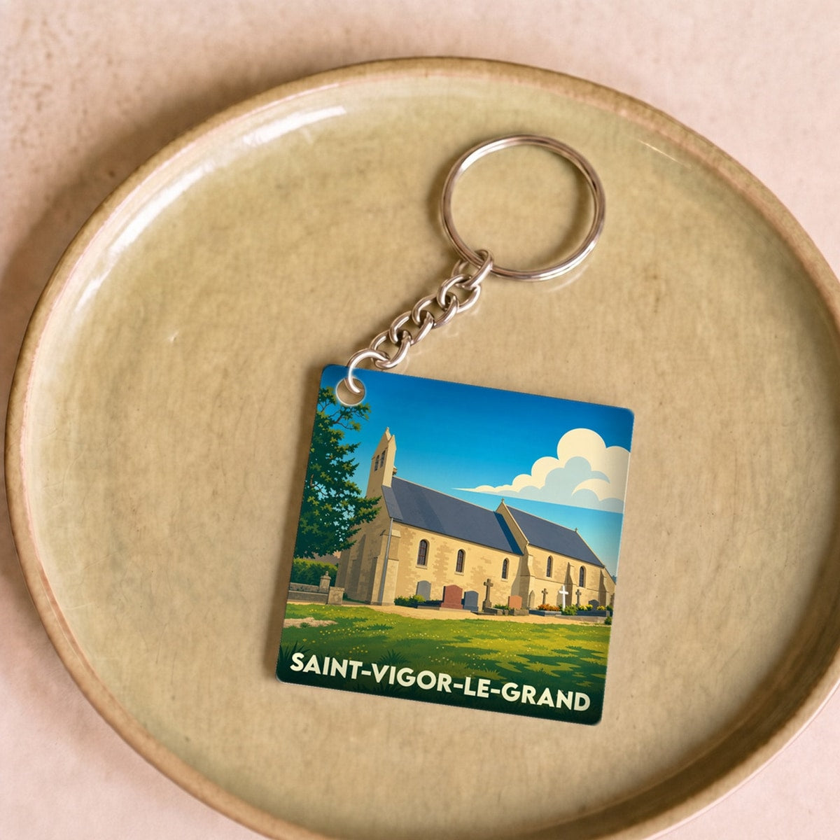 Porte-clés souvenir de la ville de Saint-Vigor-le-Grand avec une illustration stylisée d'une église.