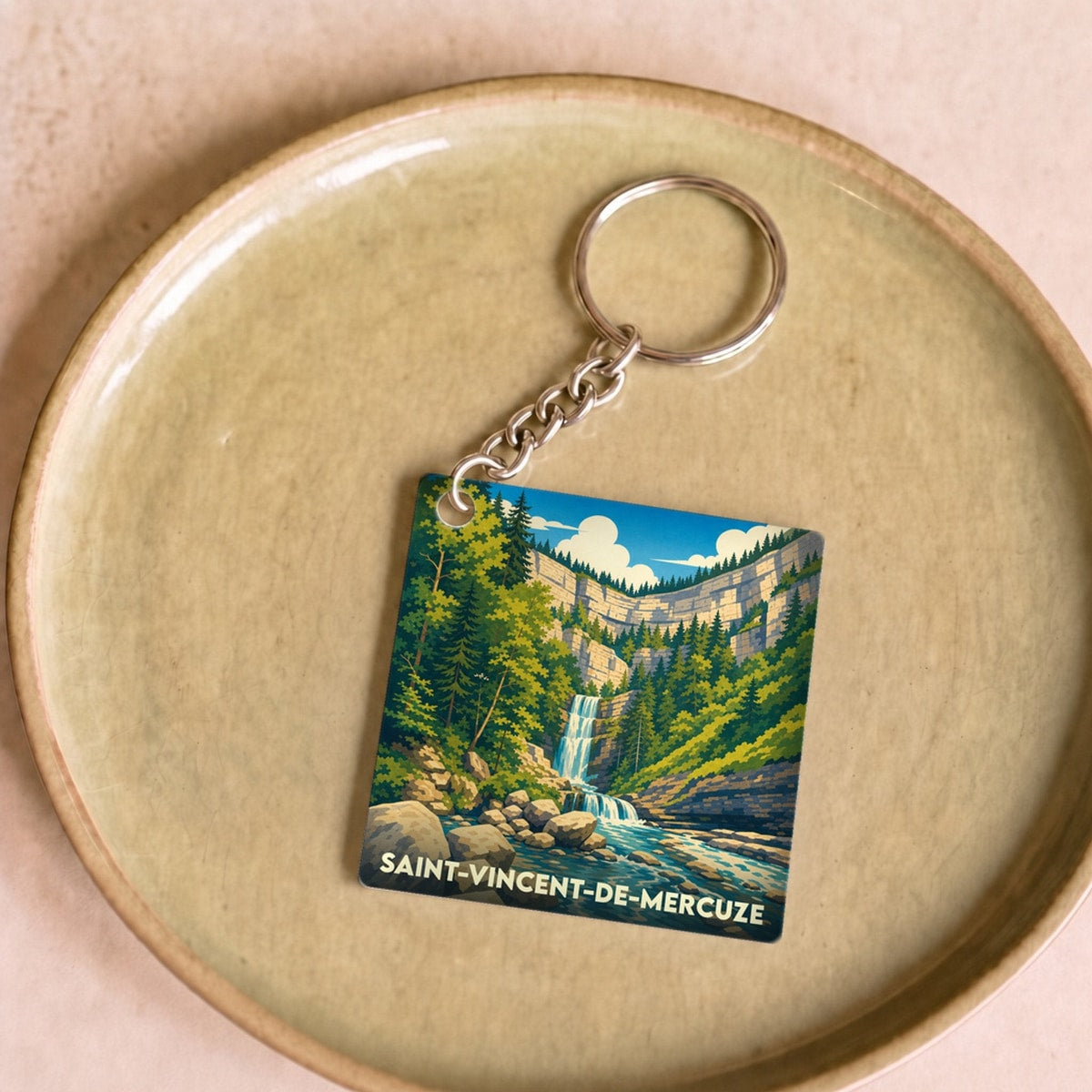 Porte-clés souvenir de la ville de Saint-Vincent-de-Mercuze avec une illustration stylisée d'une cascade.