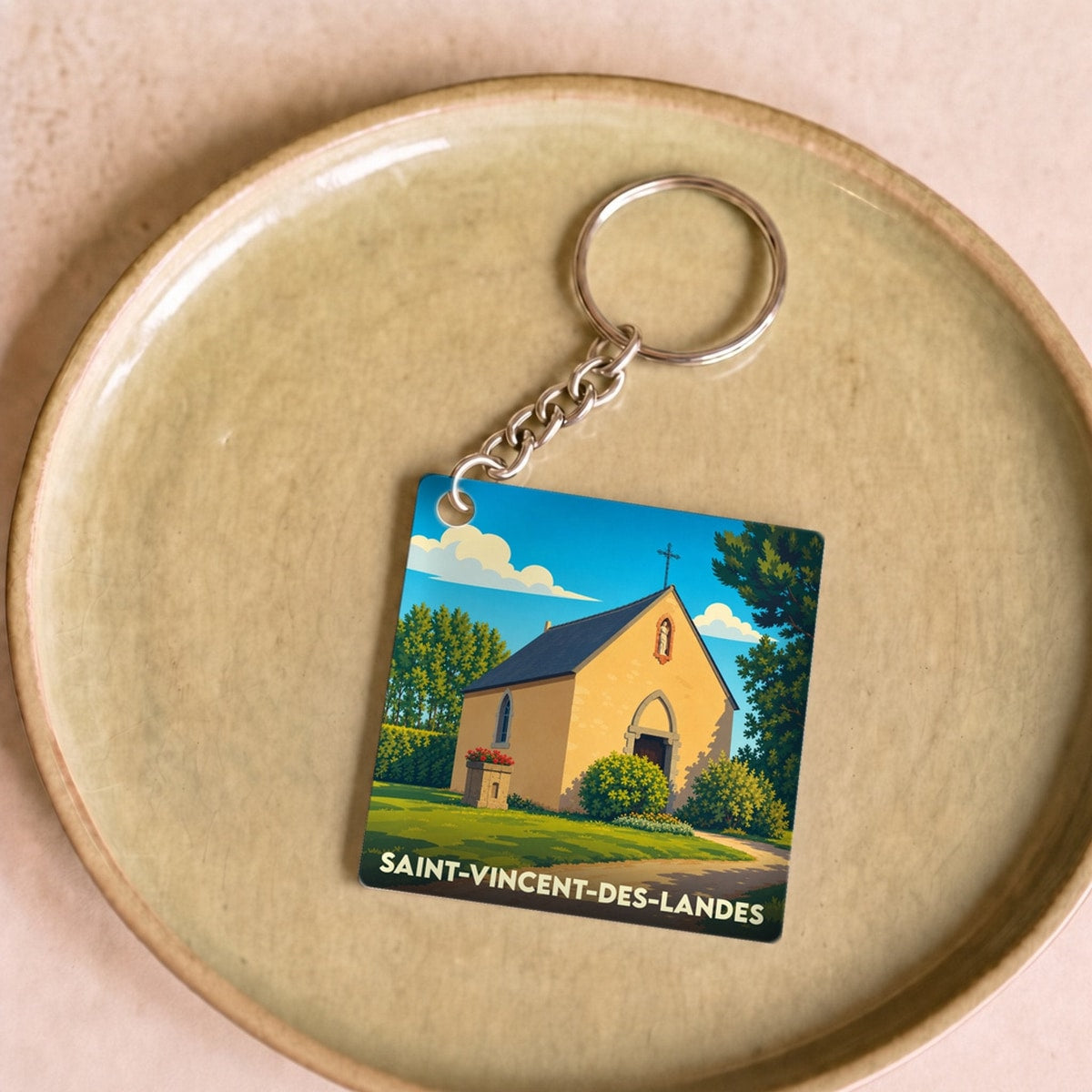 Porte-clés souvenir de la ville de Saint-Vincent-des-Landes avec une illustration stylisée d'une chapelle.