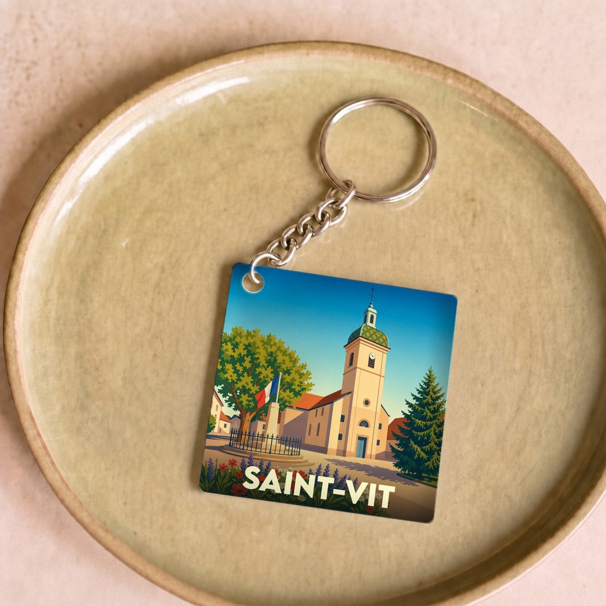 Porte-clés souvenir de la ville de Saint-Vit avec une illustration colorée et stylisée de son église.