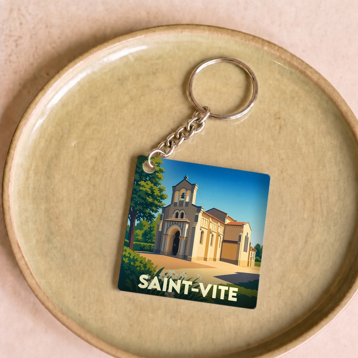 Porte-clés souvenir de la ville de Saint-Vite avec une illustration stylisée de son église.