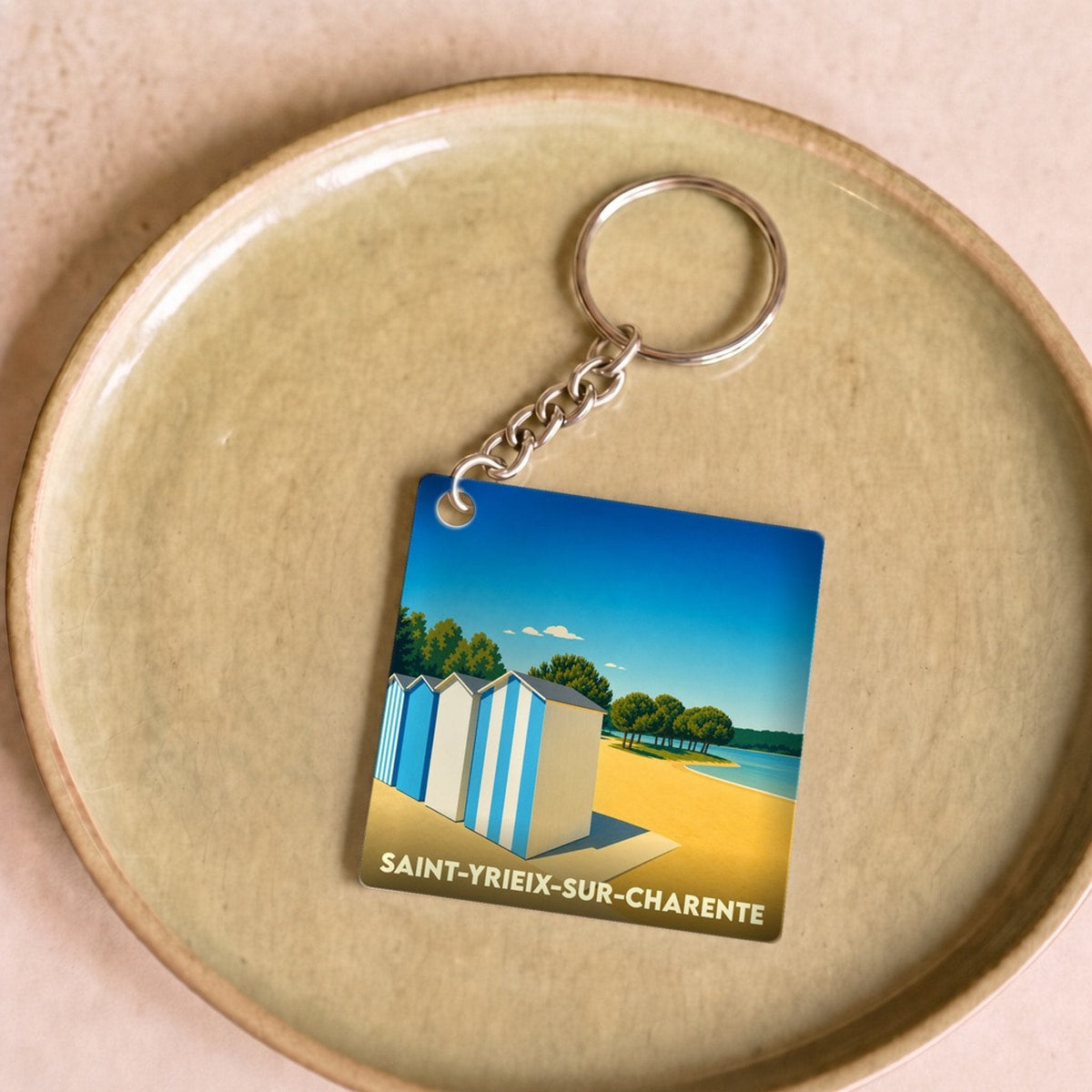 Porte-clés souvenir de la ville de Saint-Yrieix-sur-Charente avec une illustration stylisée de cabines de plage.