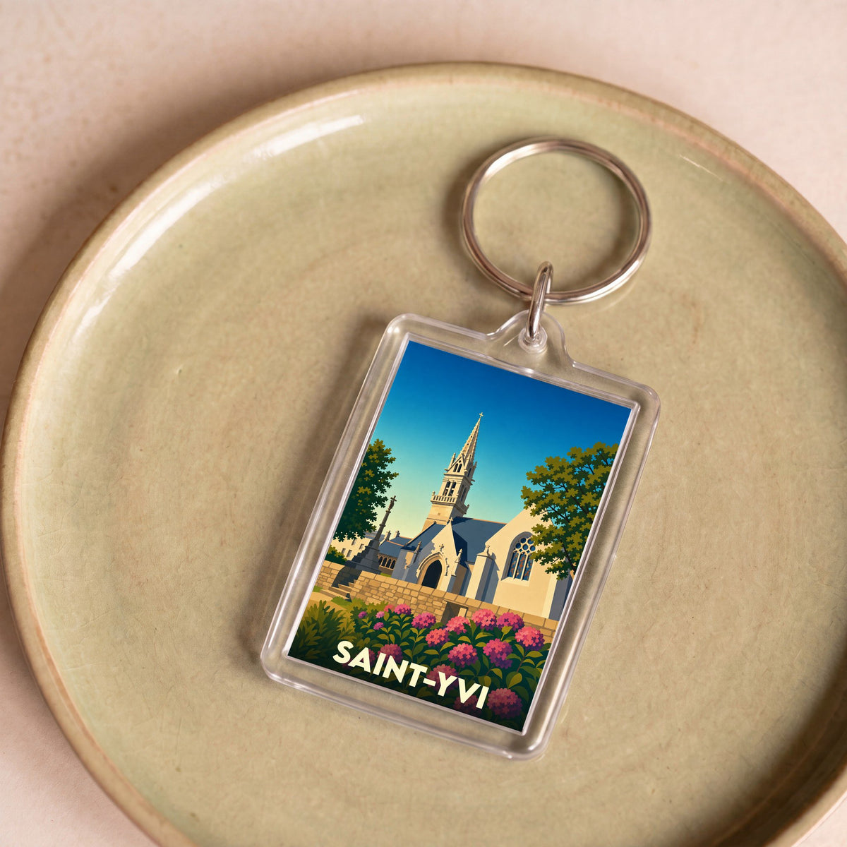 Porte-clés souvenir de la ville de Saint-Yvi avec une illustration stylisée de son église.