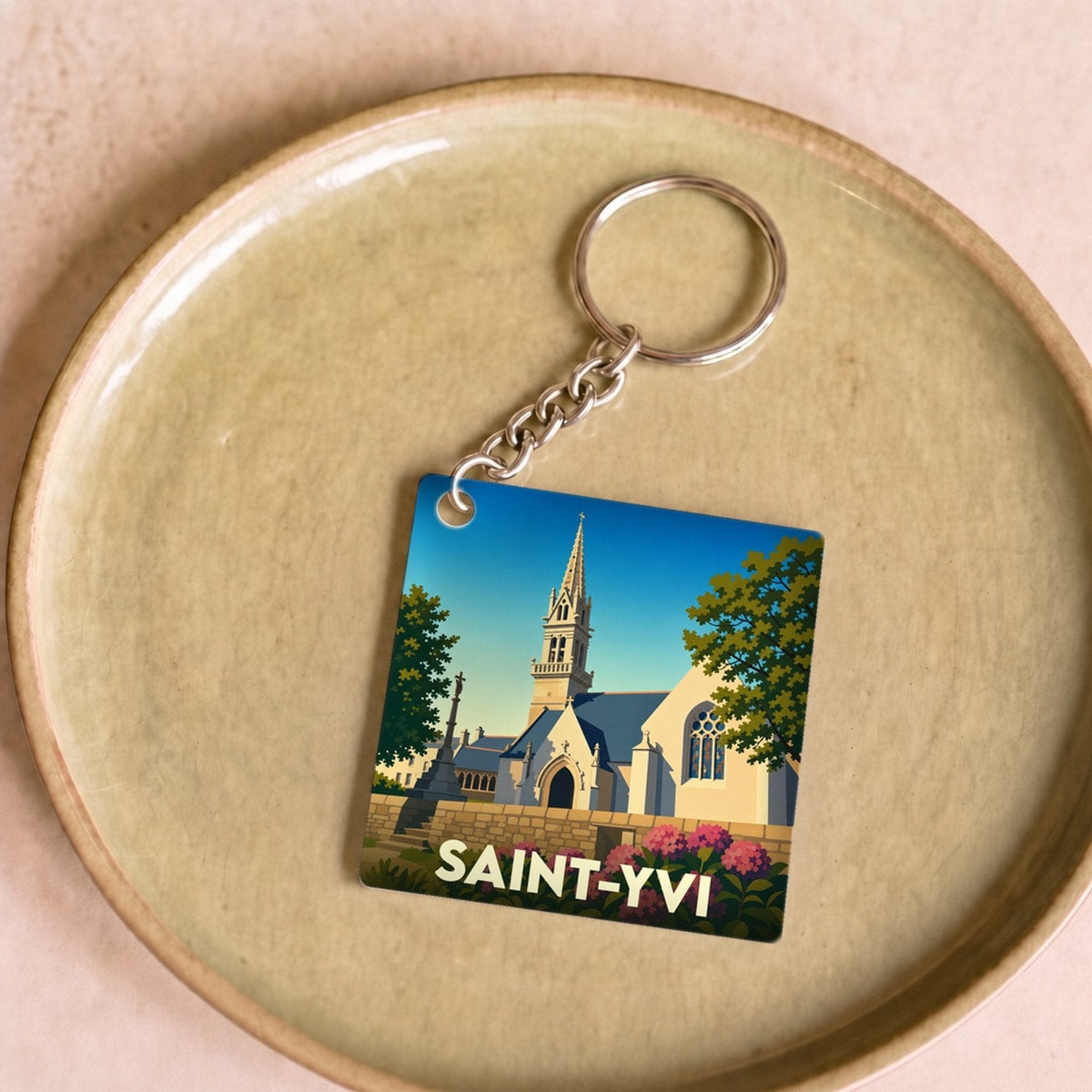 Porte-clés souvenir de la ville de Saint-Yvi avec une illustration stylisée de son église.