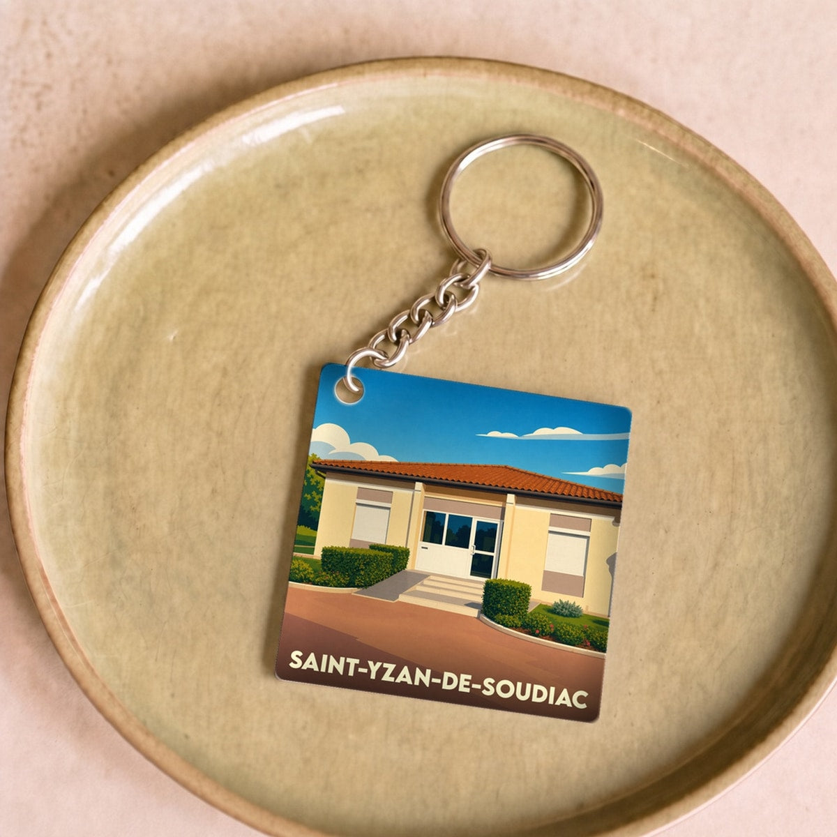 Porte-clés souvenir de la ville de Saint-Yzan-de-Soudiac avec une illustration stylisée.
