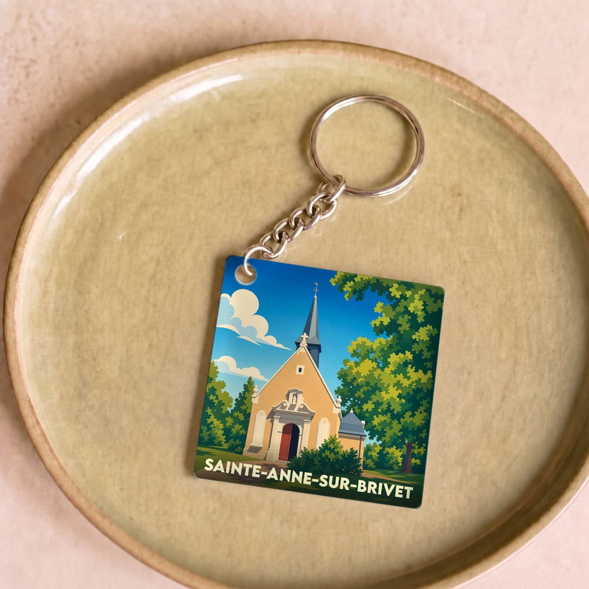 Porte-clés souvenir de la ville de Sainte-Anne-sur-Brivet avec une illustration stylisée de sa chapelle.
