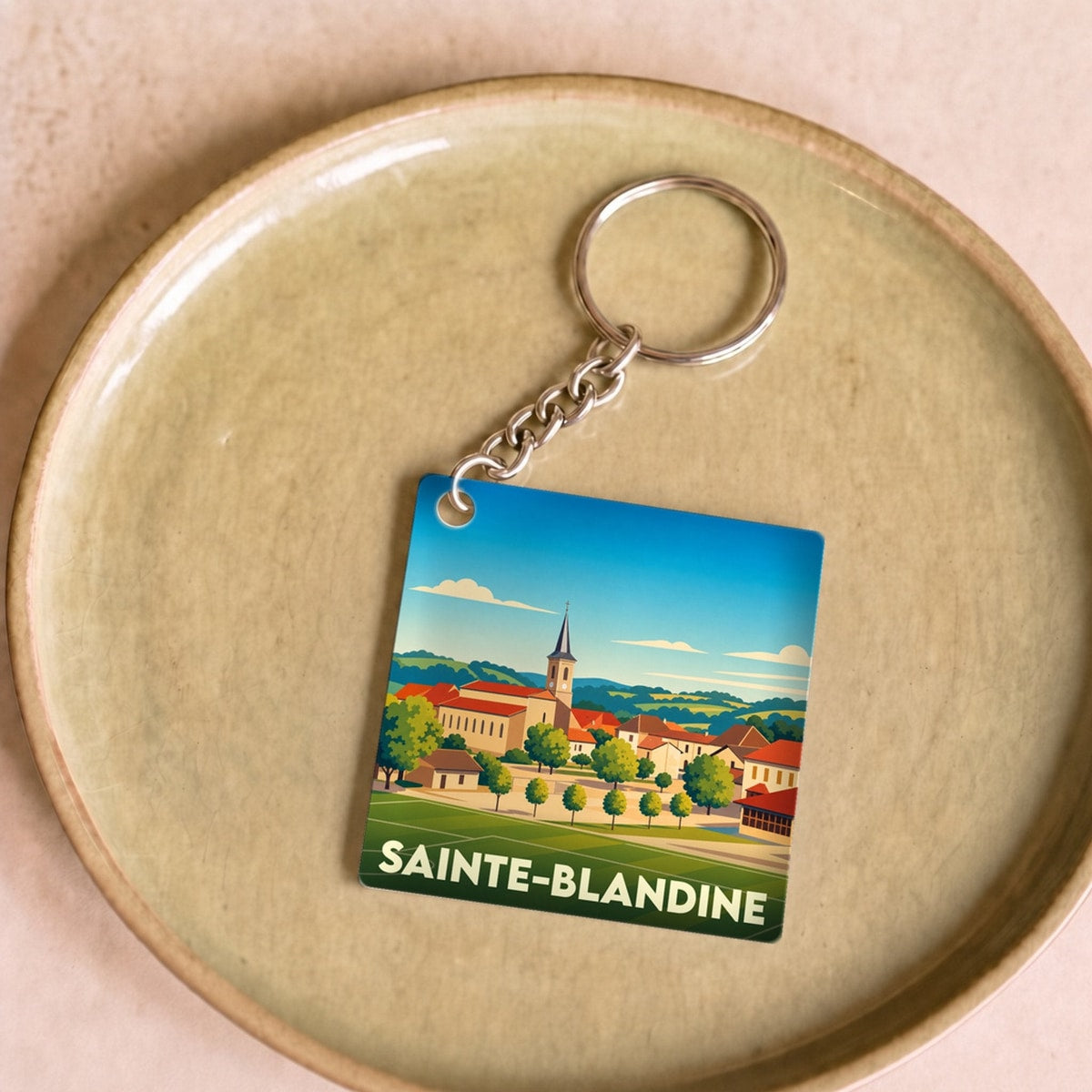 Porte-clés souvenir de la ville de Sainte-Blandine avec une illustration stylisée.
