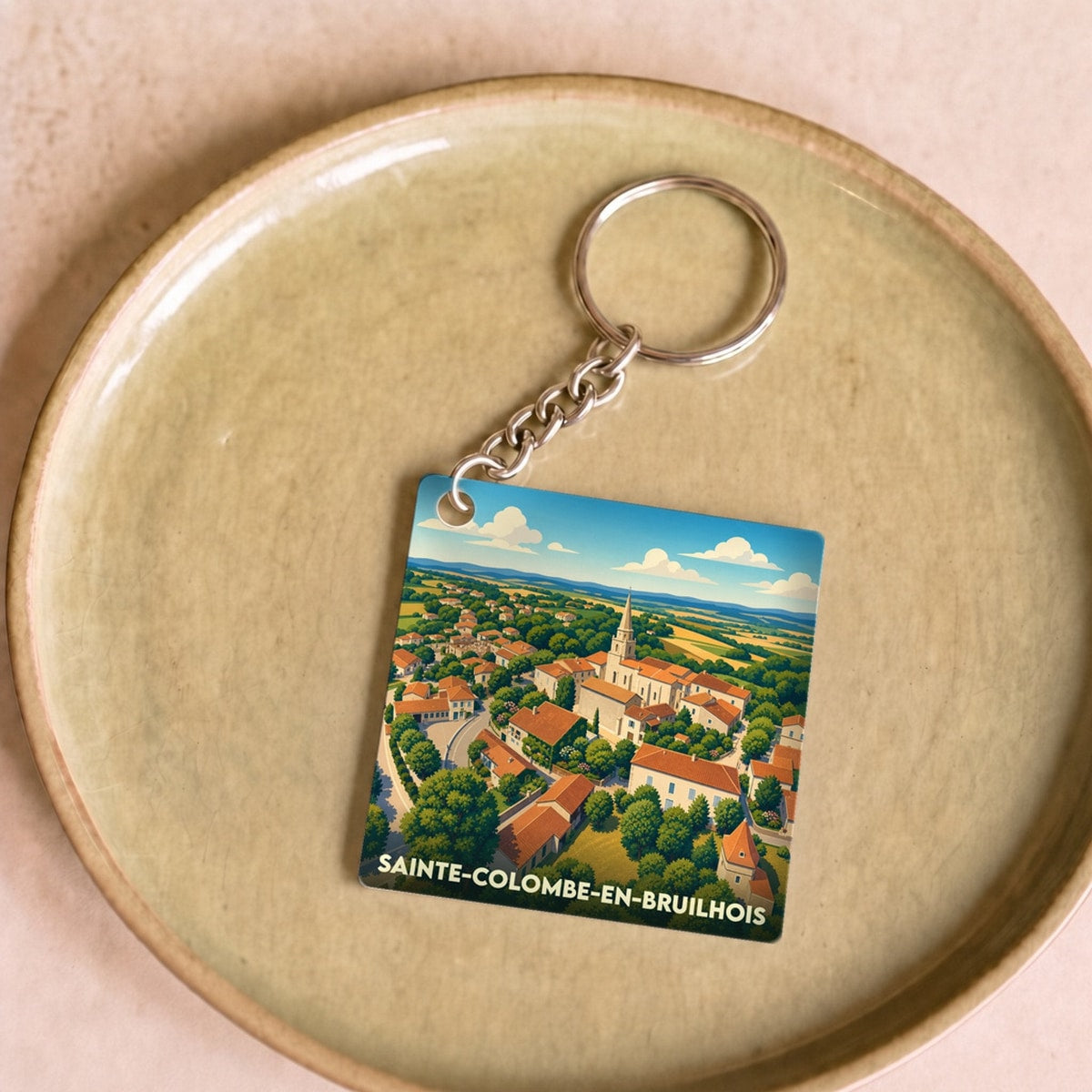 Porte-clés souvenir de la ville de Sainte-Colombe-en-Bruilhois avec une illustration stylisée.