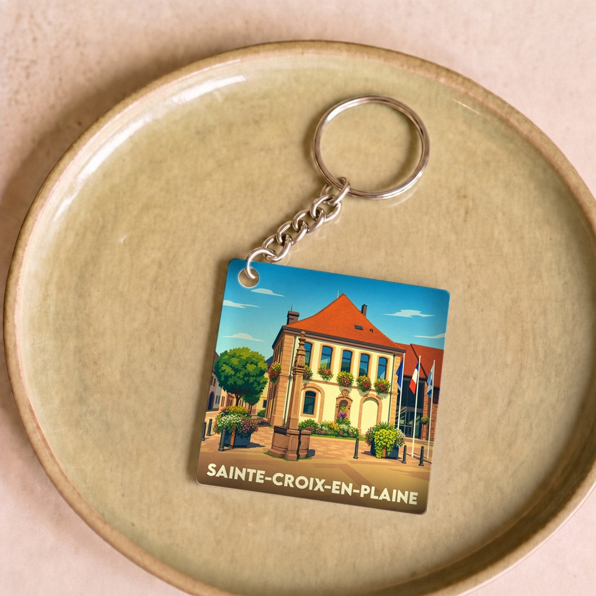 Porte-clés souvenir de la ville de Sainte-Croix-en-Plaine avec une illustration stylisée.