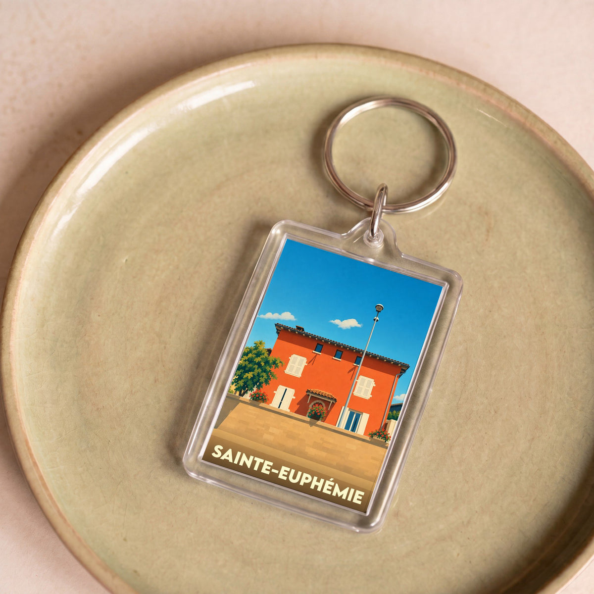 Porte-clés souvenir de la ville de Sainte-Euphémie avec une illustration stylisée.