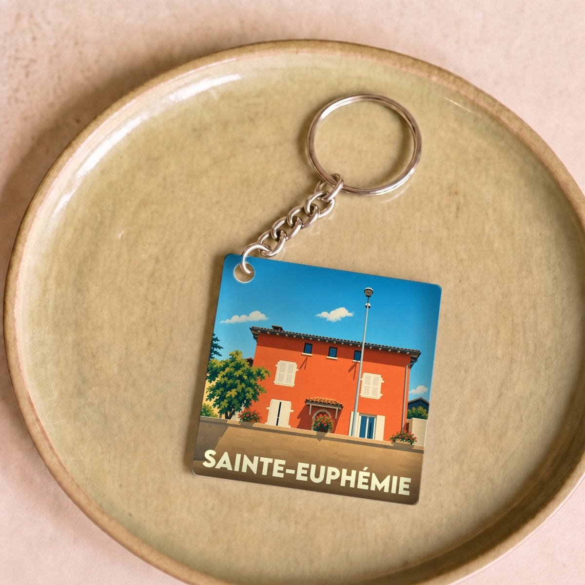 Porte-clés souvenir de la ville de Sainte-Euphémie avec une illustration stylisée.
