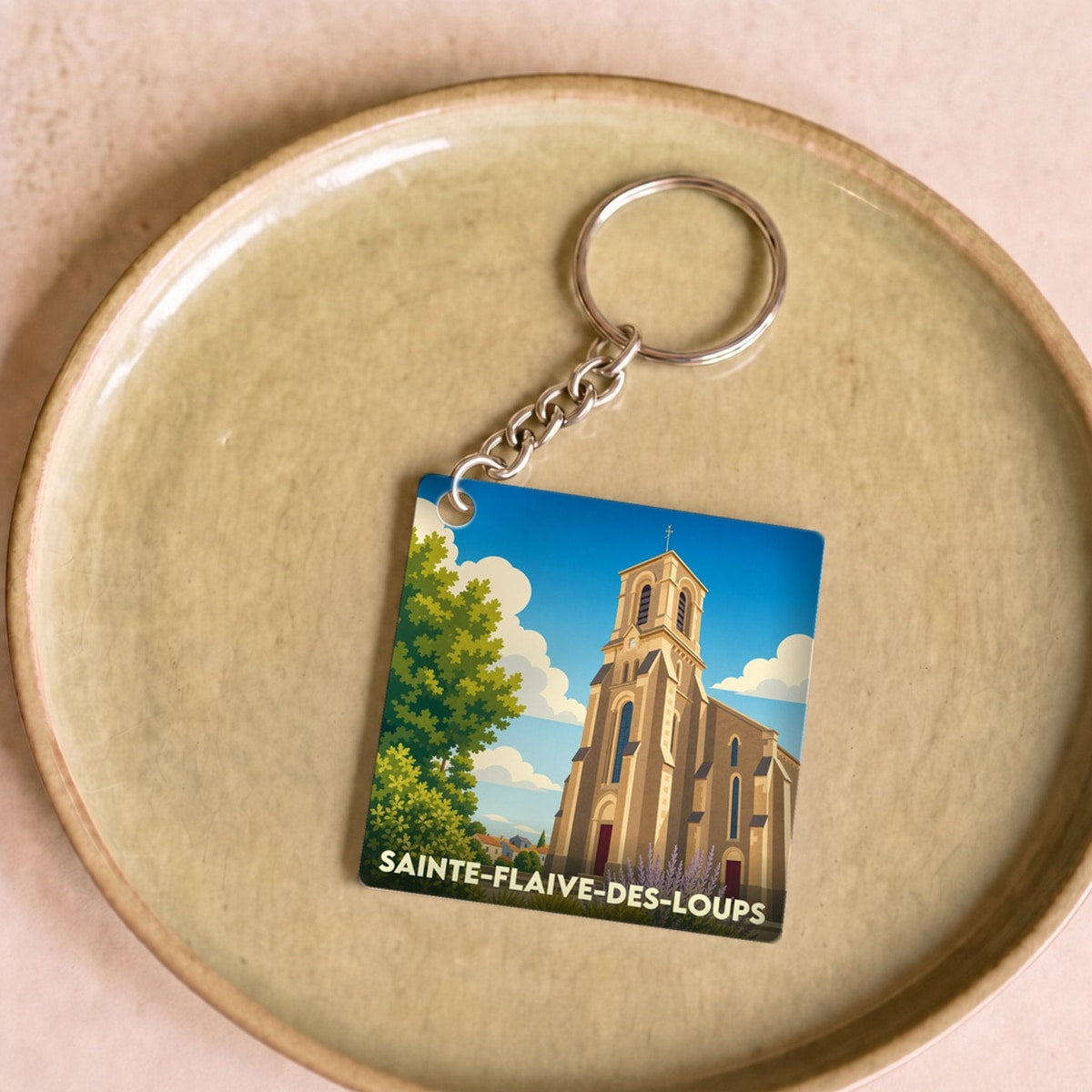 Porte-clés souvenir de la ville de Sainte-Flaive-des-Loups avec une illustration stylisée de son église.