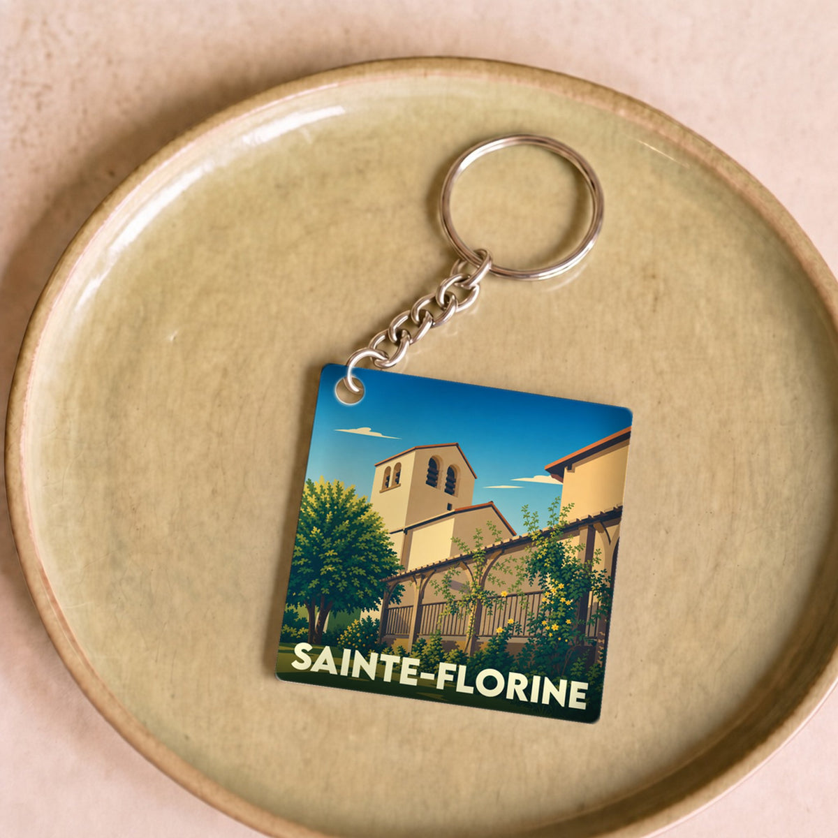 Porte-clés souvenir de la ville de Sainte-Florine avec une illustration stylisée.