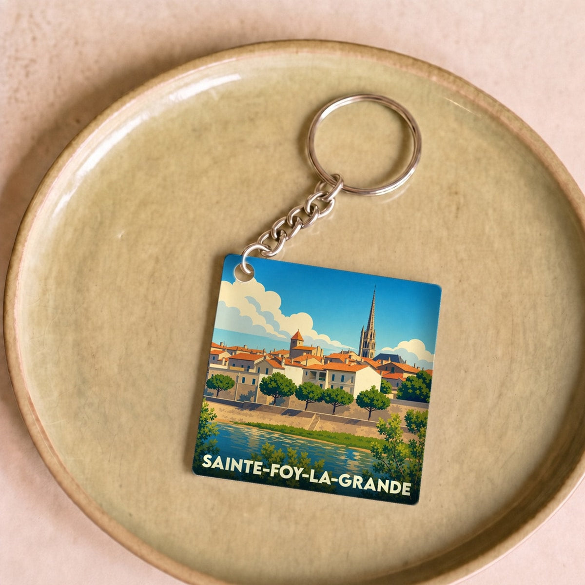 Porte-clés souvenir de la ville de Sainte-Foy-la-Grande avec une illustration stylisée.