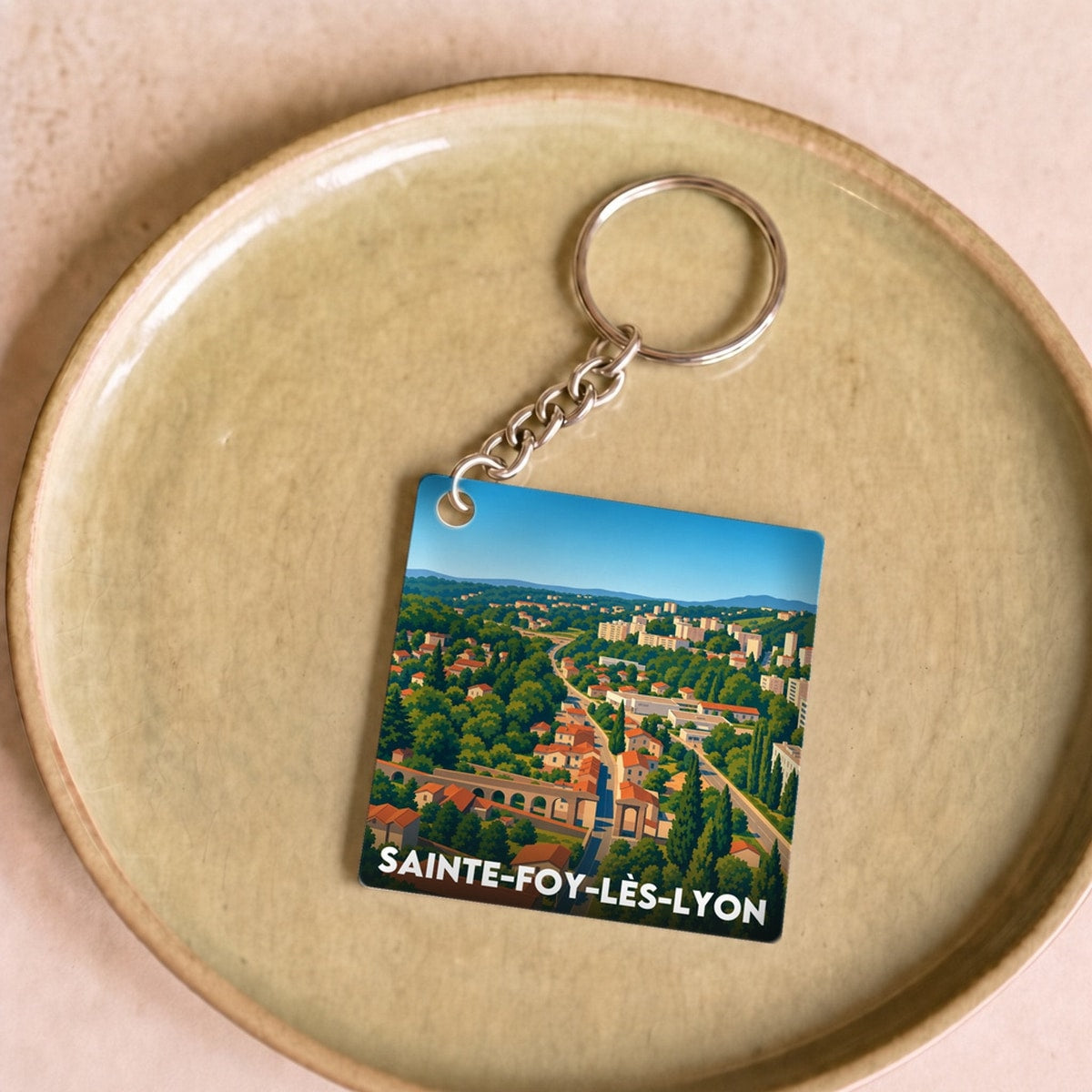 Porte-clés souvenir de la ville de Sainte-Foy-lès-Lyon avec une illustration stylisée.