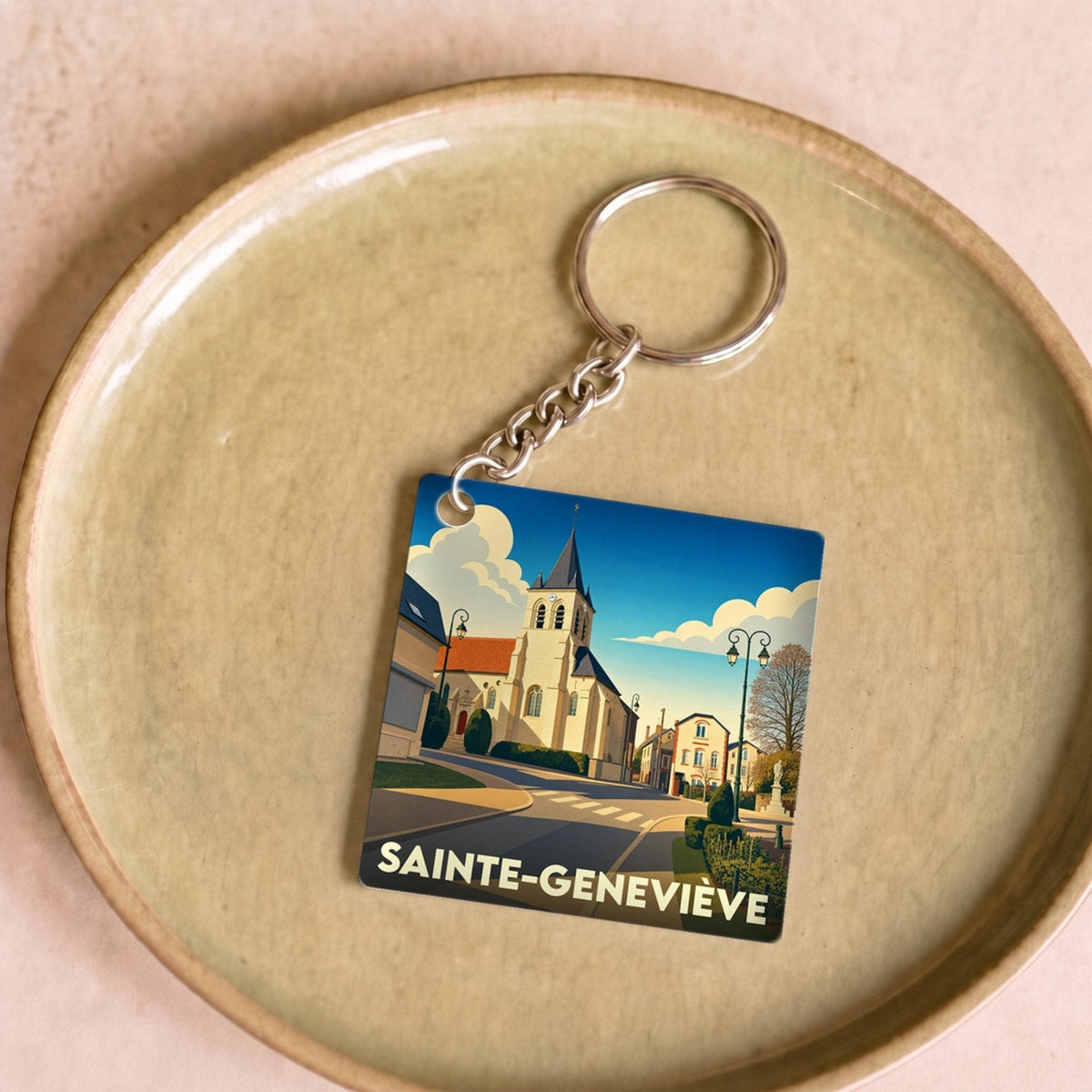 Porte-clés souvenir de la ville de Sainte-Geneviève avec une illustration stylisée.