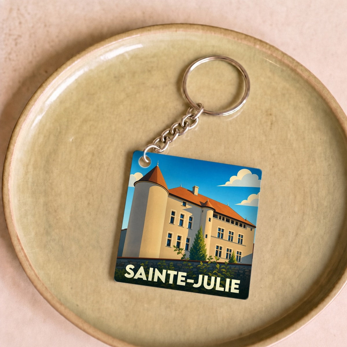 Porte-clés souvenir de la ville de Sainte-Julie avec une illustration stylisée.