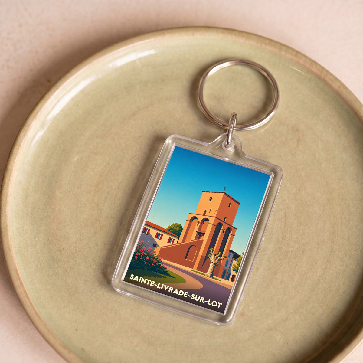 Porte-clés souvenir de la ville de Sainte-Livrade-sur-Lot avec une illustration stylisée de son église.