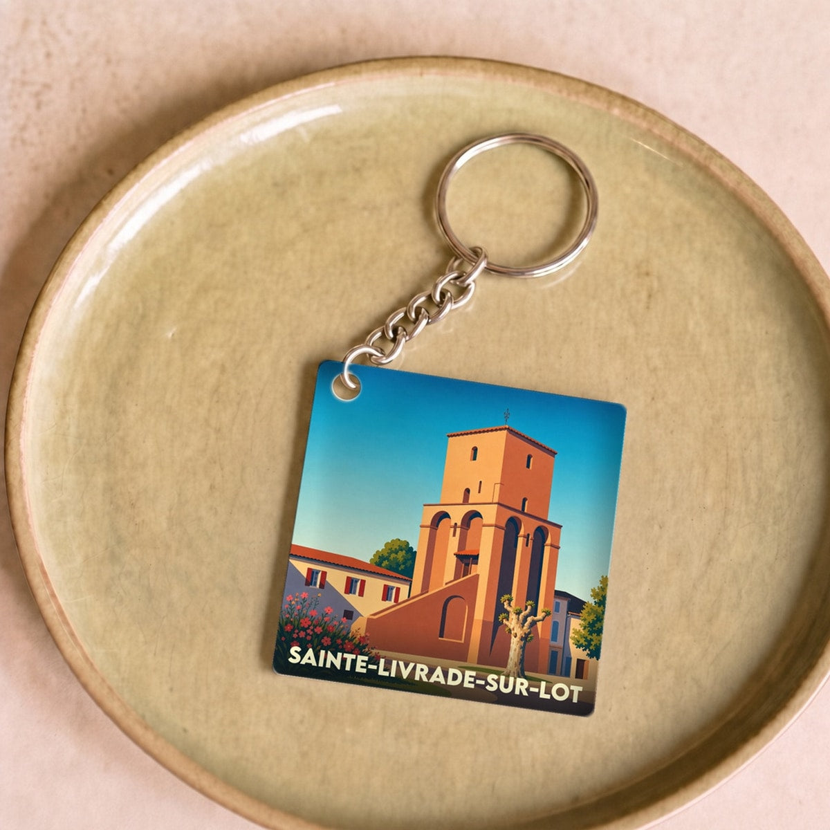 Porte-clés souvenir de la ville de Sainte-Livrade-sur-Lot avec une illustration stylisée de son église.