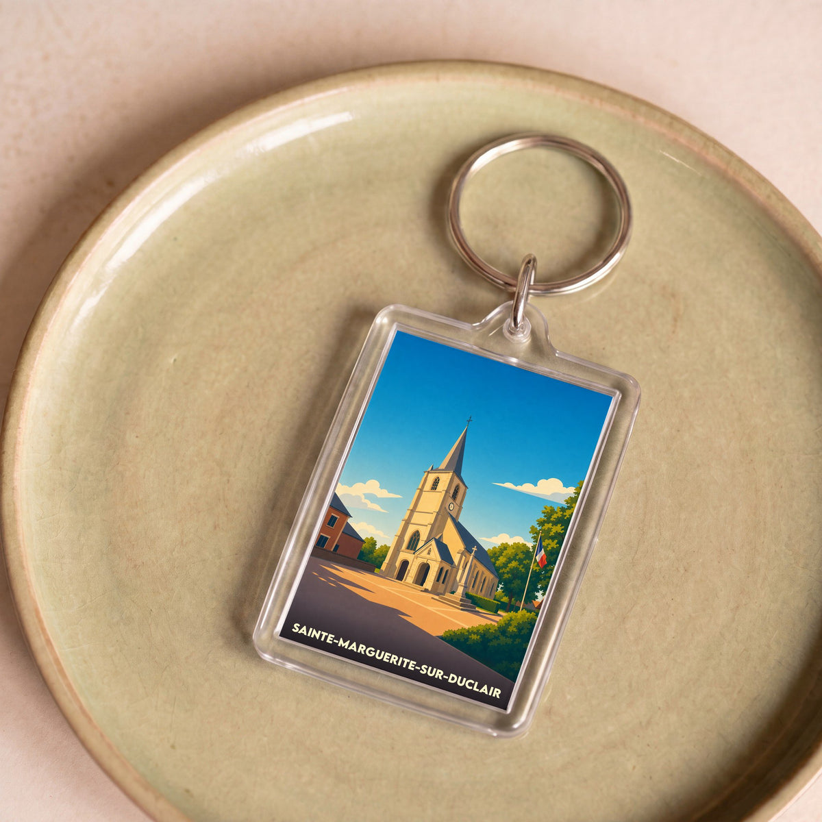 Porte-clés souvenir de la ville de Sainte-Marguerite-sur-Duclair avec une illustration stylisée de son église.