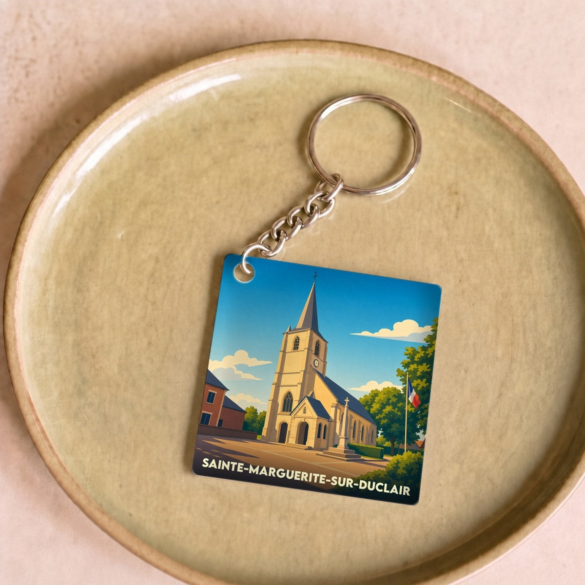 Porte-clés souvenir de la ville de Sainte-Marguerite-sur-Duclair avec une illustration stylisée de son église.