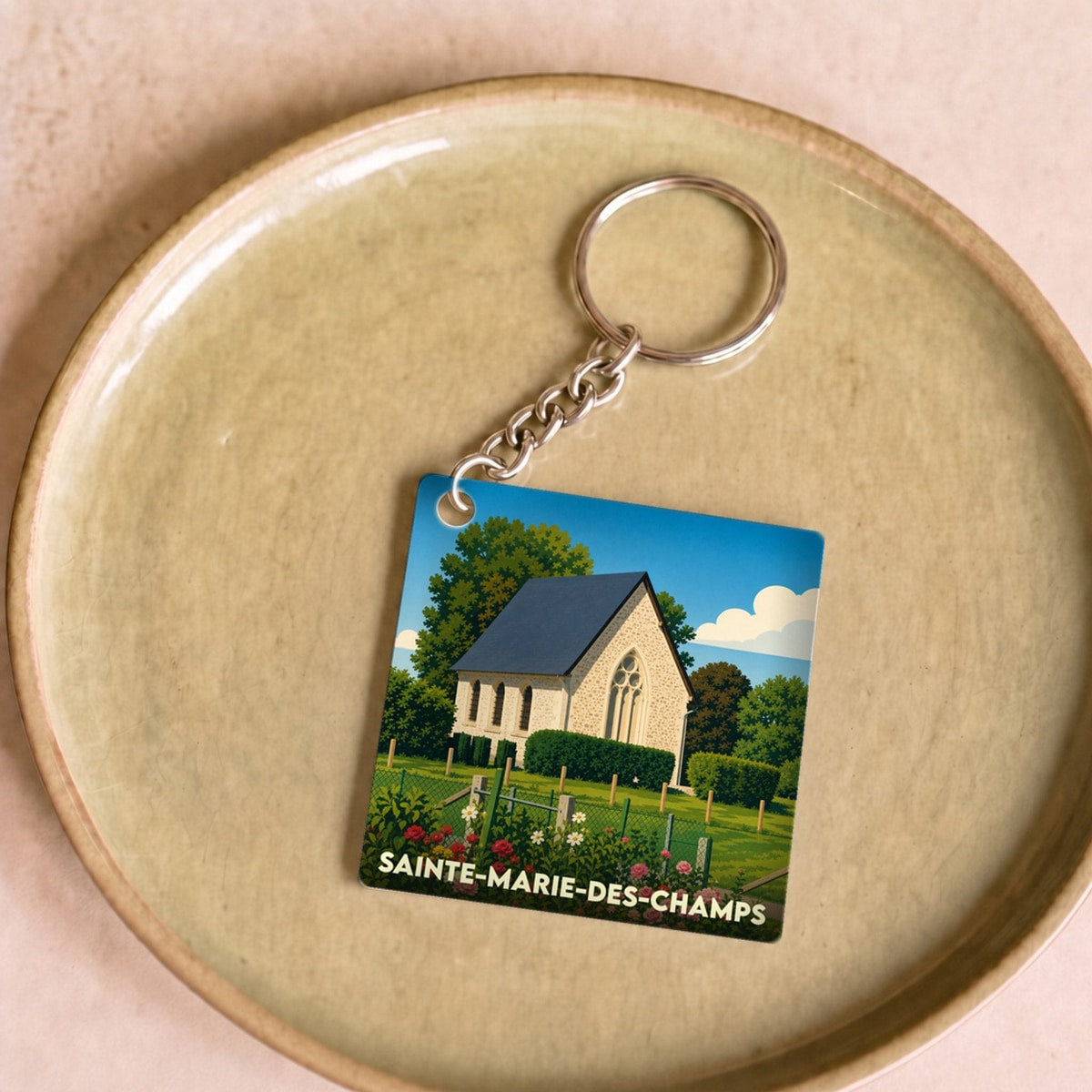 Porte-clés souvenir de la ville de Sainte-Marie-des-Champs avec une illustration stylisée d'une église.