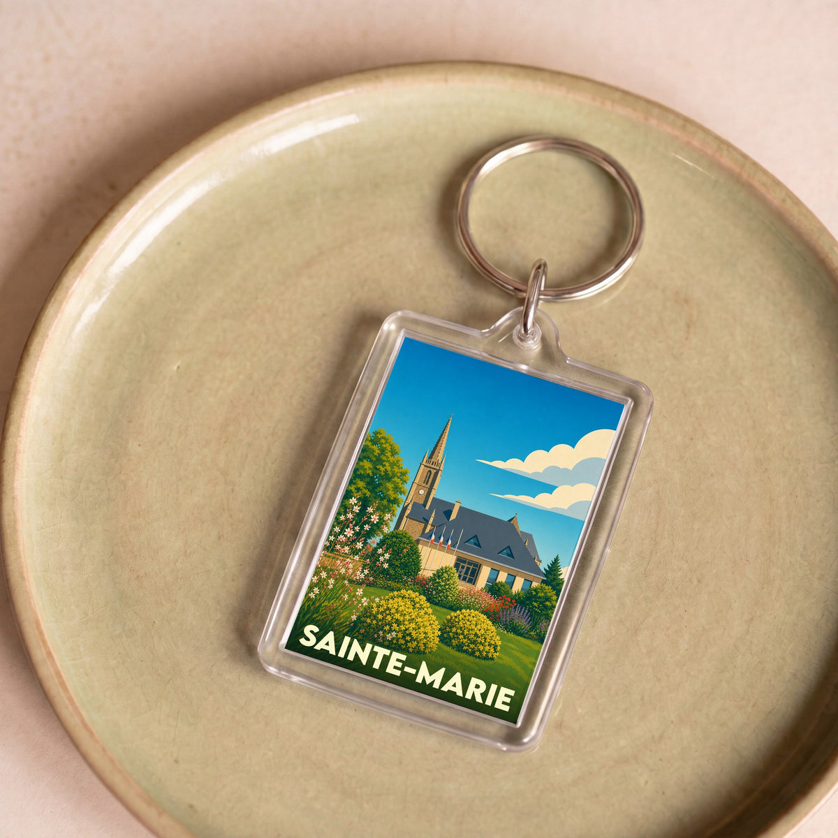 Porte-clés souvenir de la ville de Sainte-Marie avec une illustration stylisée d'un paysage urbain fleuri.