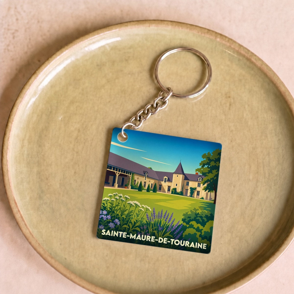 Porte-clés souvenir de la ville de Sainte-Maure-de-Touraine avec une illustration stylisée.