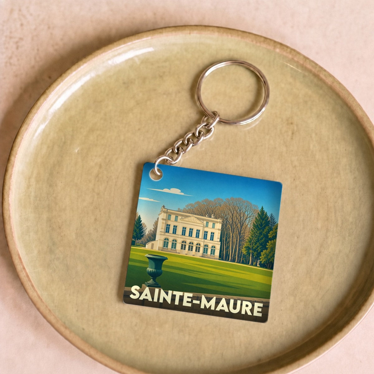 Porte-clés souvenir de la ville de Sainte-Maure avec une illustration stylisée d'un château.