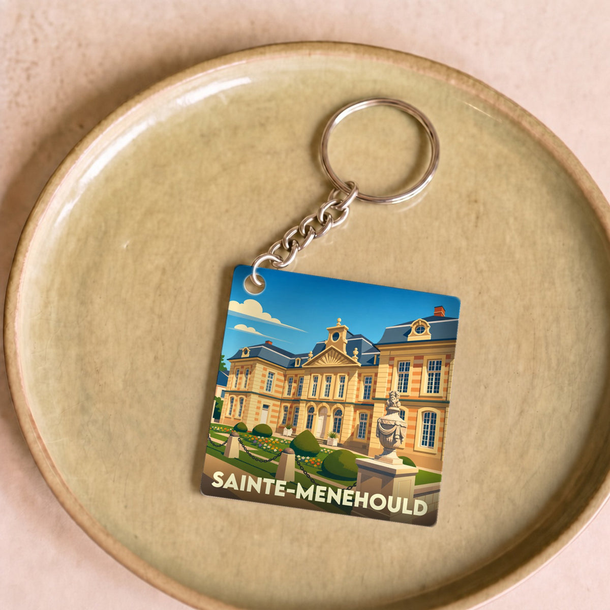 Porte-clés souvenir de la ville de Sainte-Menehould avec une illustration stylisée de son hôtel de ville.