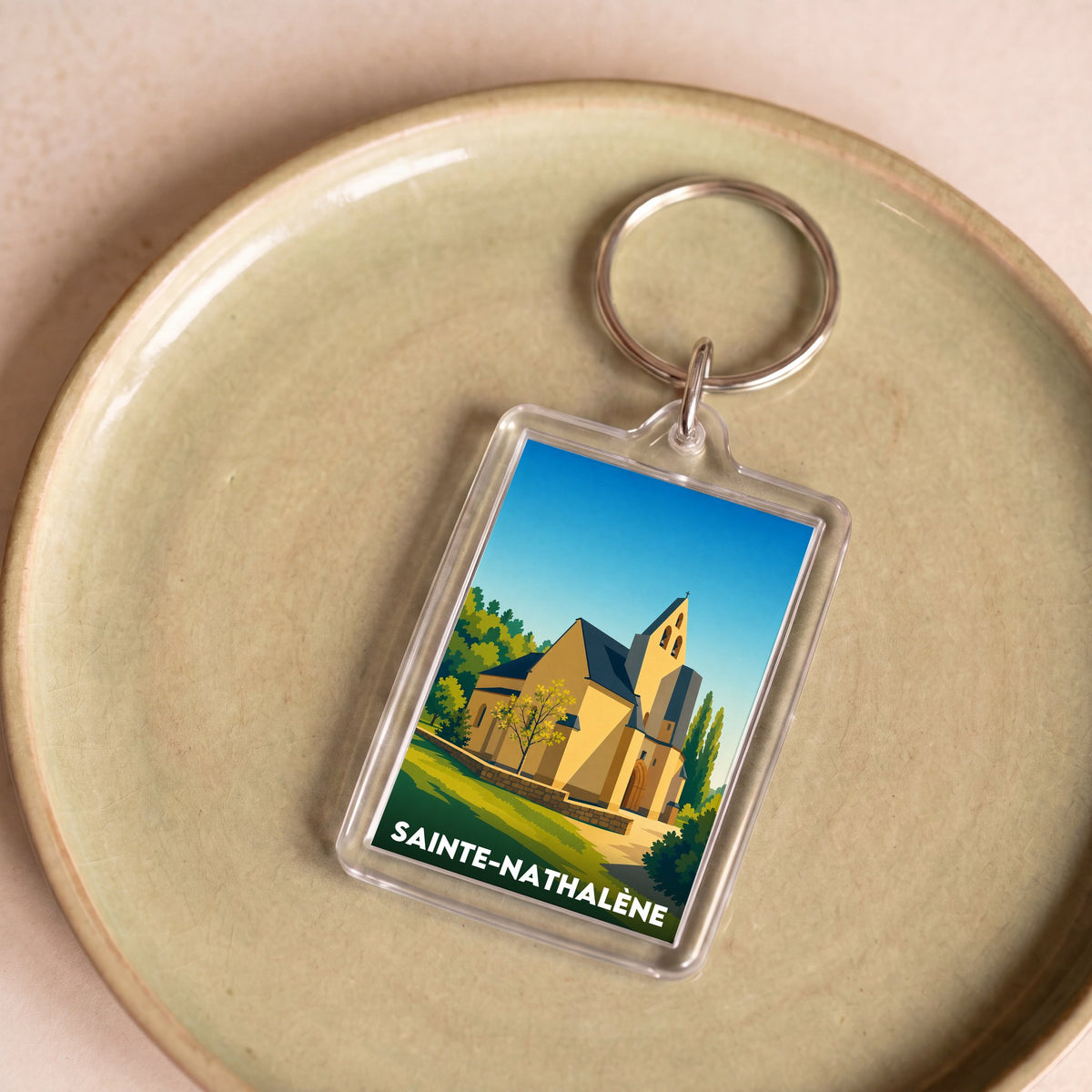 Porte-clés souvenir de la ville de Sainte-Nathalène avec une illustration stylisée.